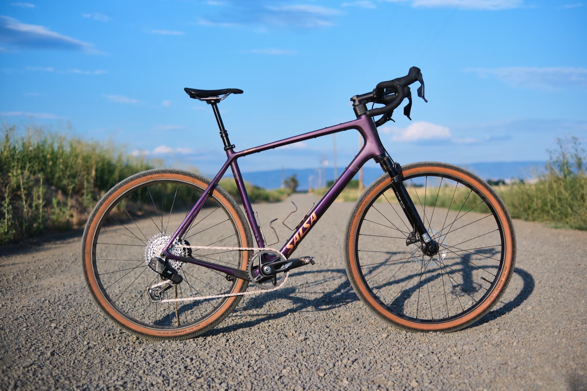 The Flyway C XPLR in profile on an empty gravel road under a big sky