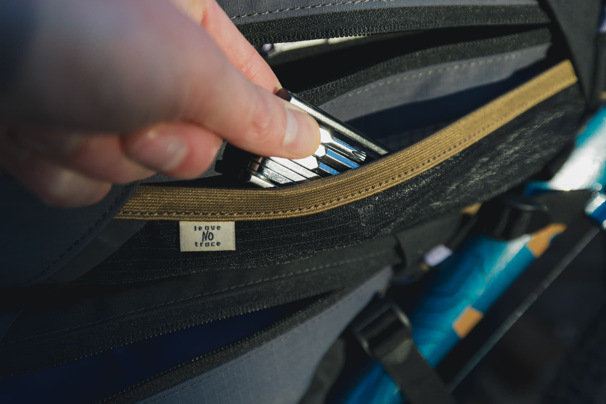 Lew grabs a tool from the bags.