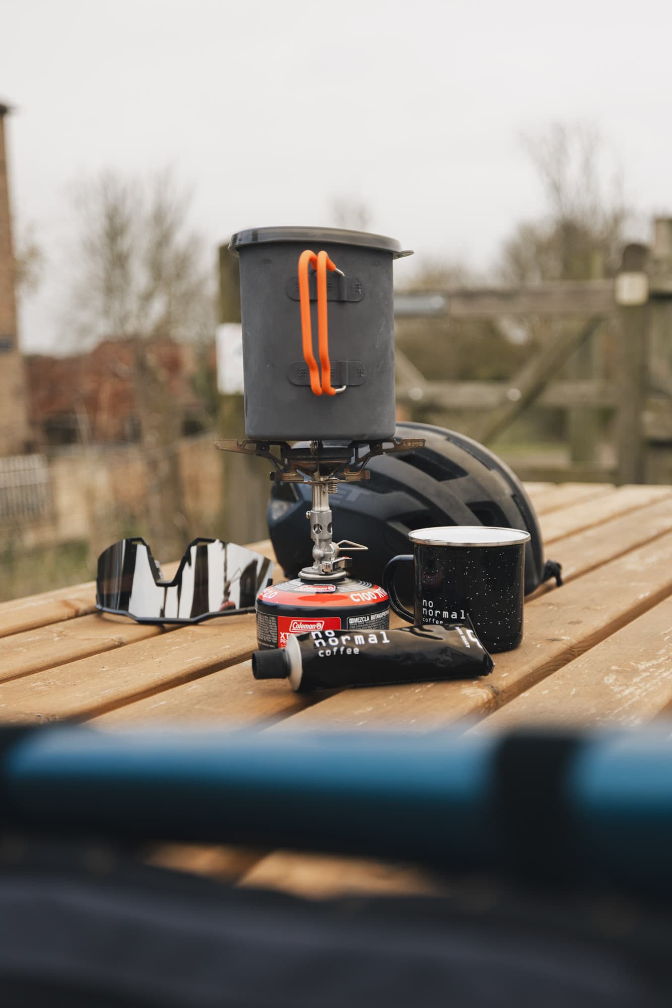 A tube of No Normal Coffee next to a camping stove.