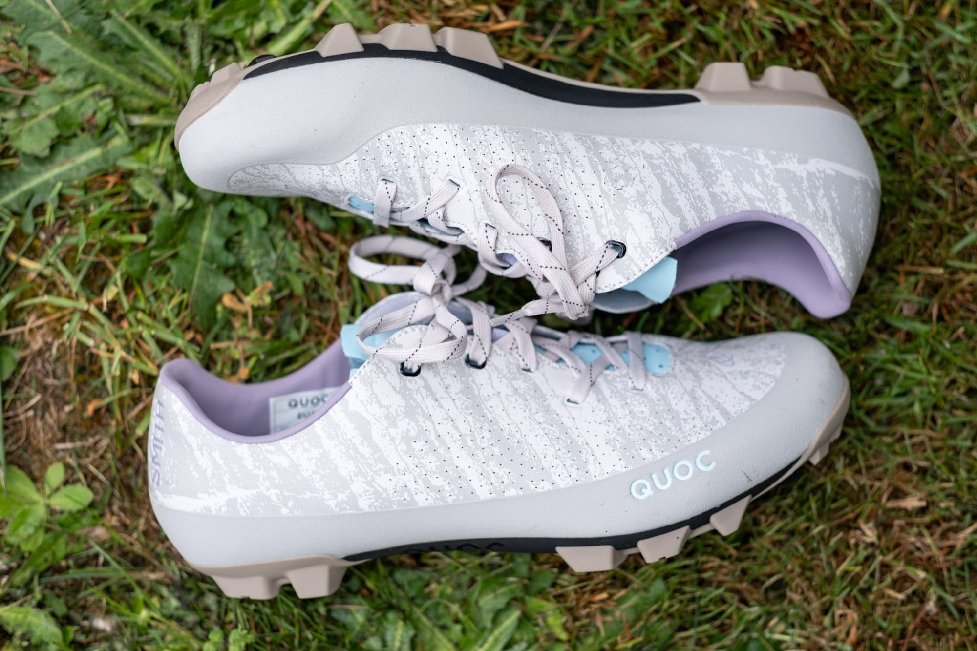 The Gran Tourer XC Lace shoes laid head to toe on the grass, showing the outsole tread.