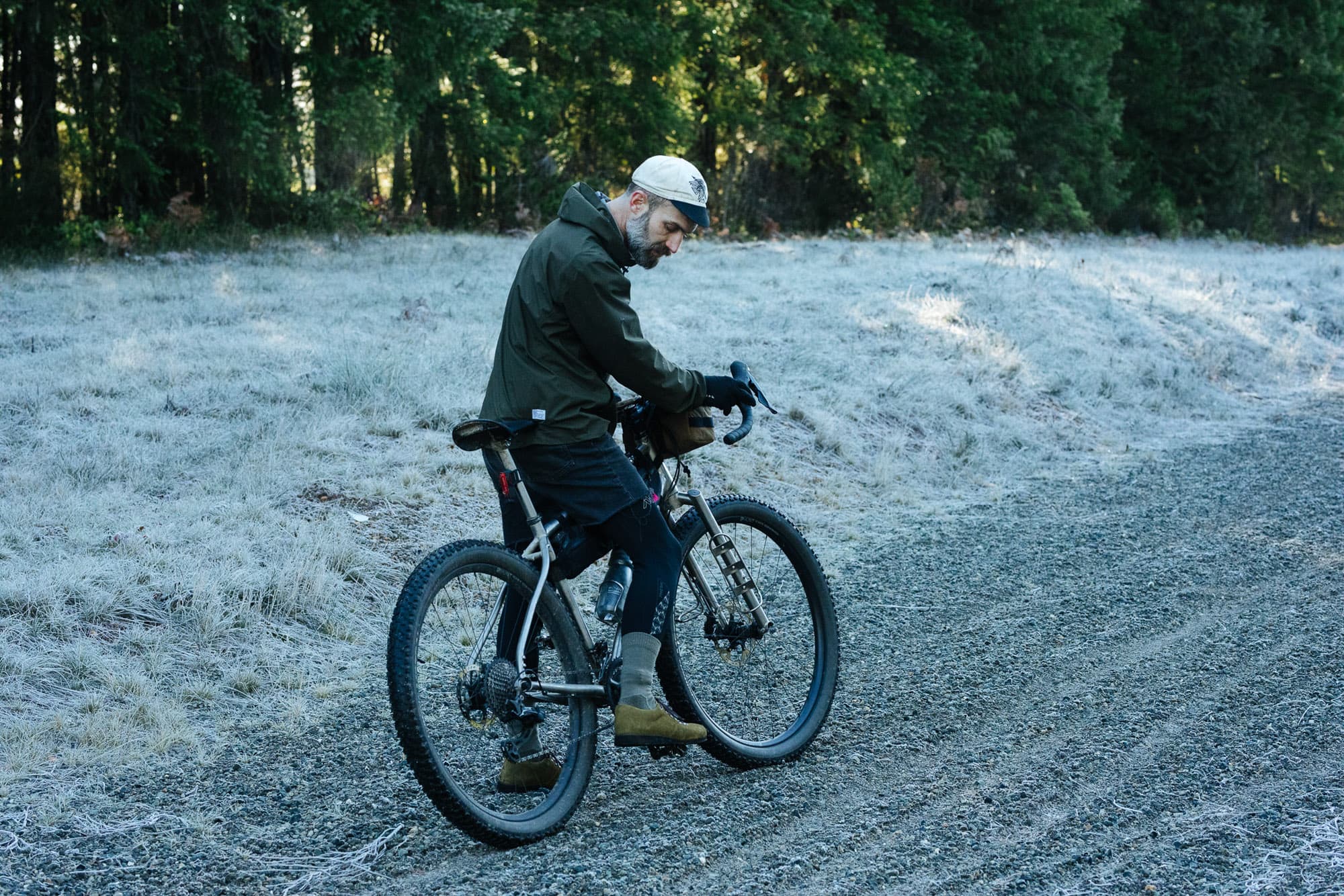 A man looks at his shoes from his bike.