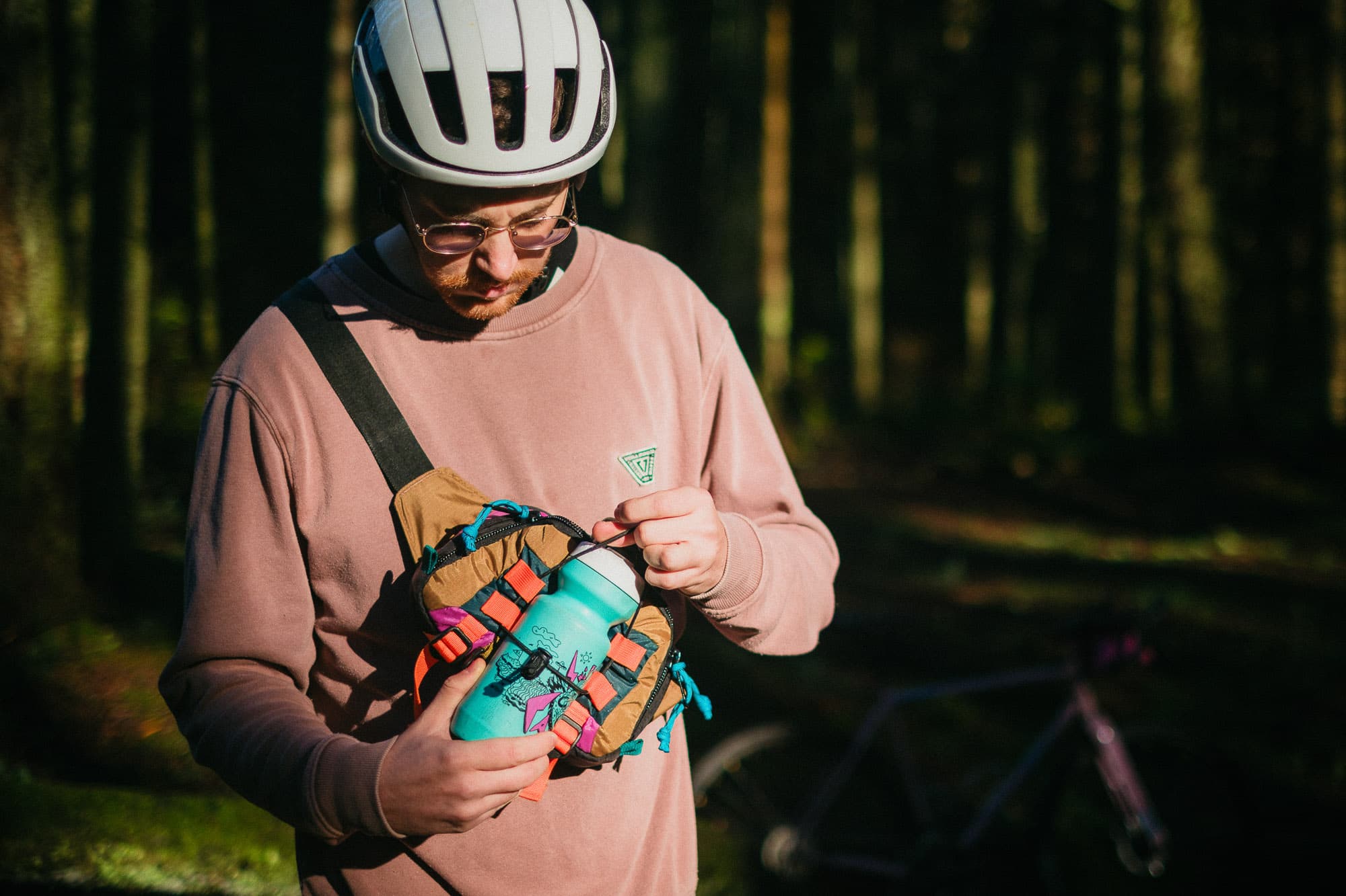 Putting a bottle into the hip pack.