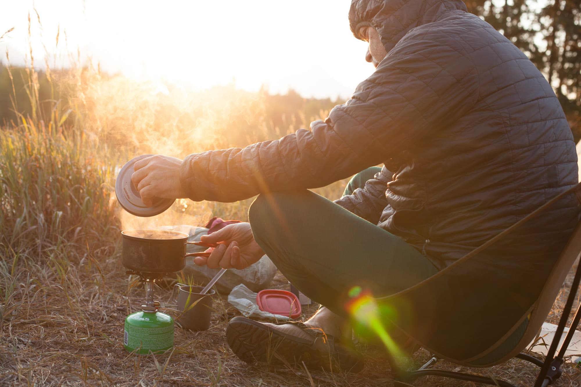 Clotaire cooking at camp in golden evening light.