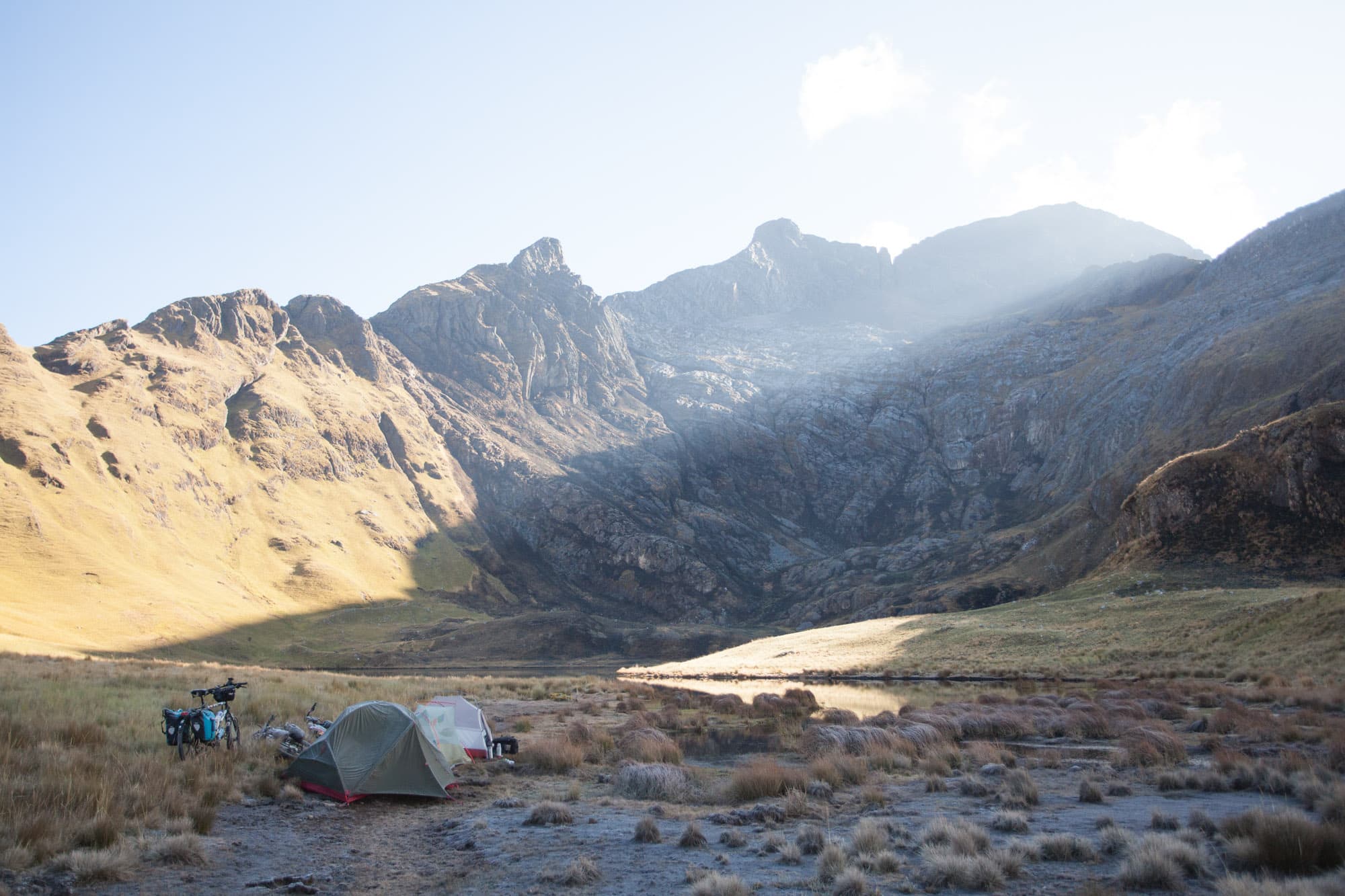 A small tent pitched in a rocky mountain valley.