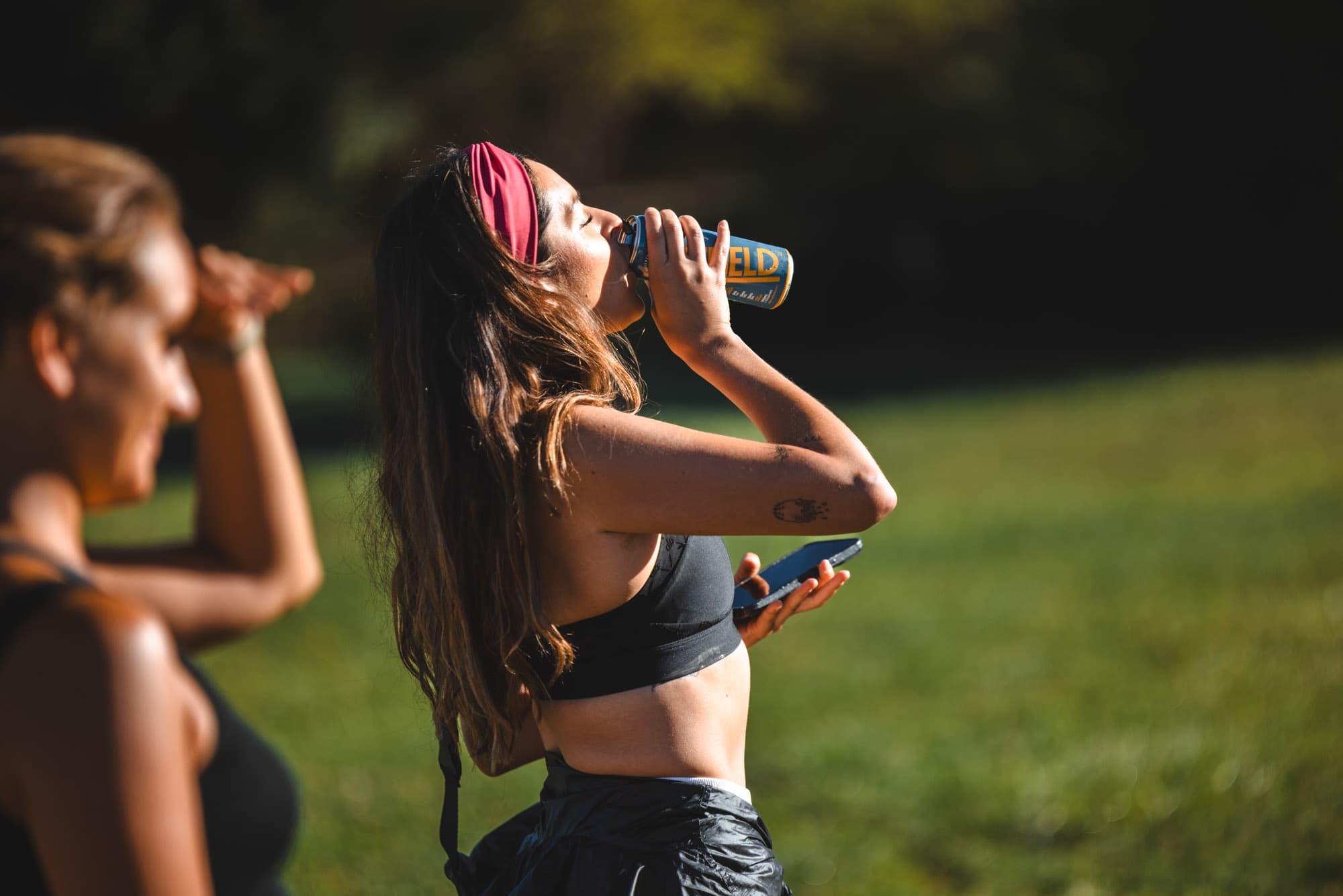 A woman takes a sip before a jog.