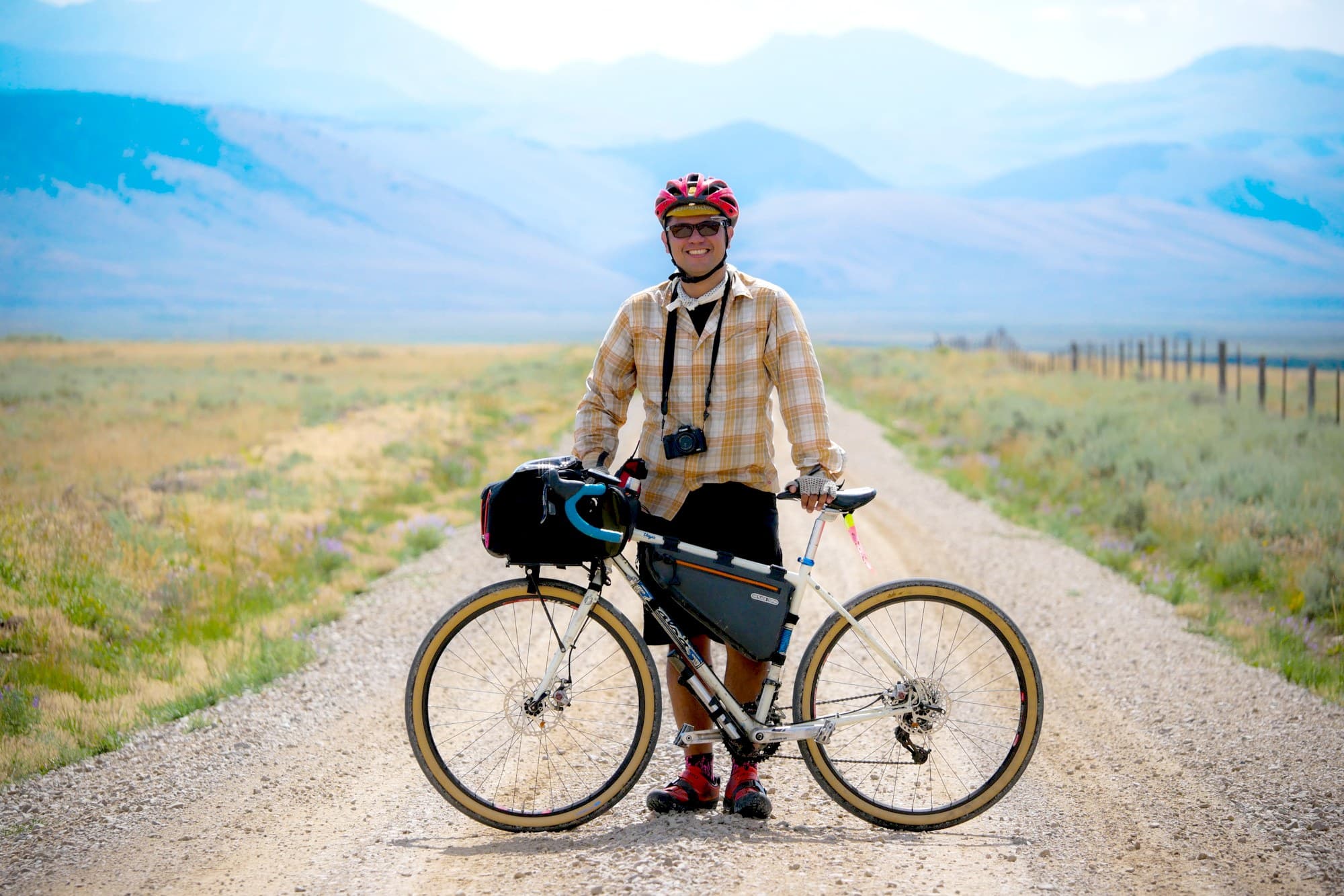 Russ of Path Less Pedaled with his loaded bike on a gravel road