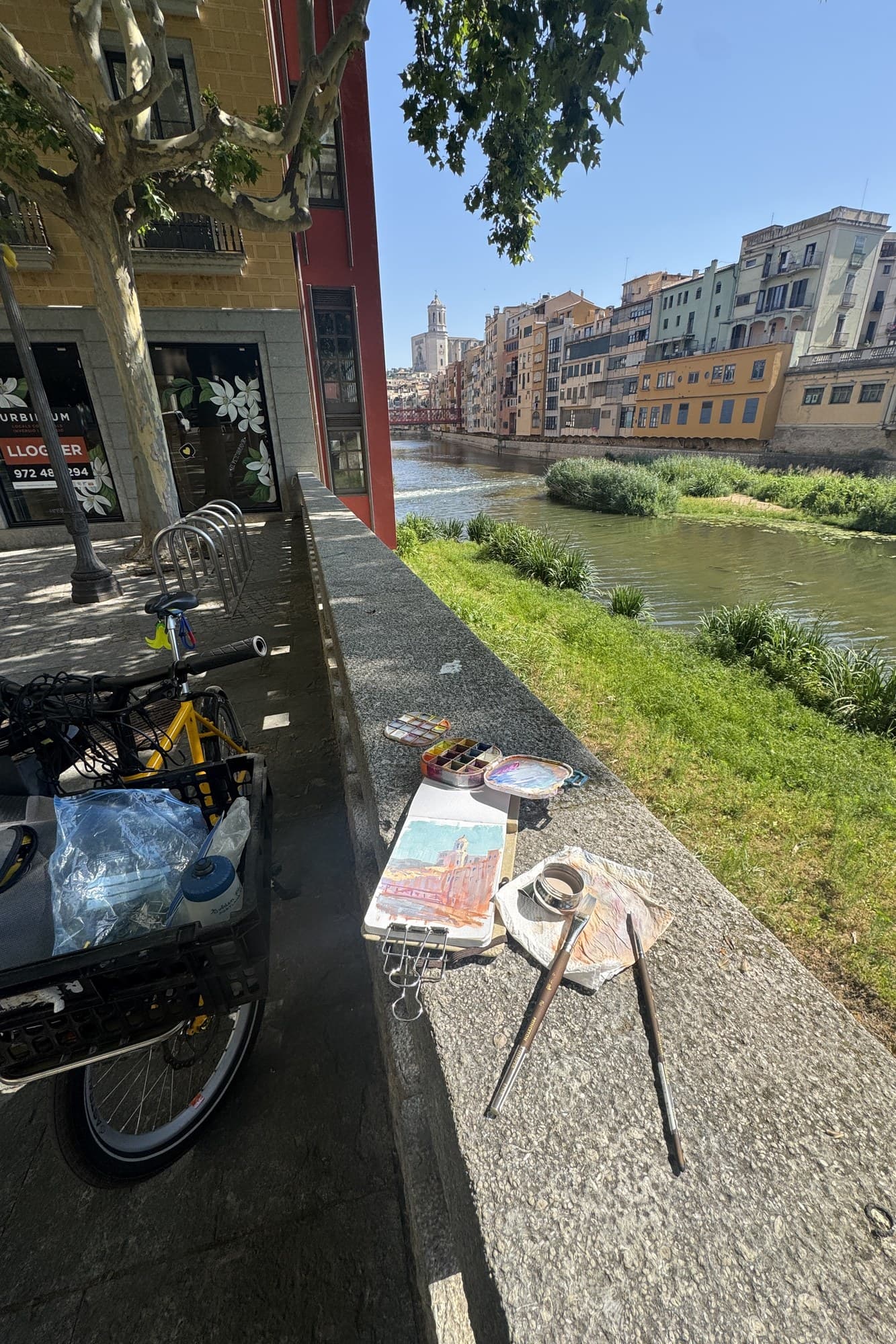 Bike and a small easel on a riverside path in town