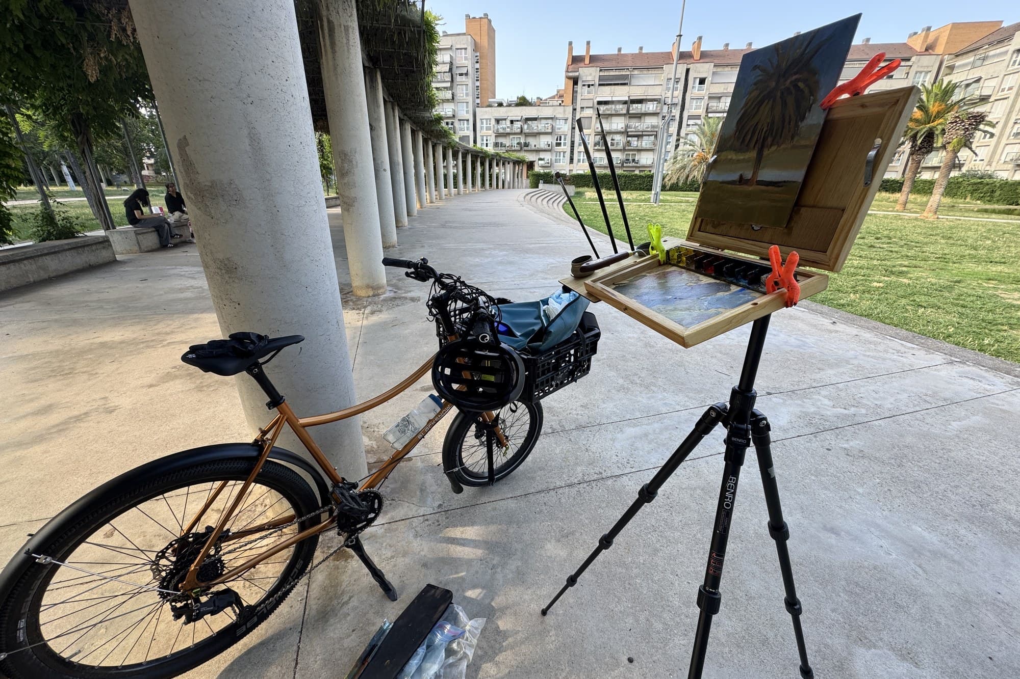 Russ' bike parked beside a tripod easel on a plaza