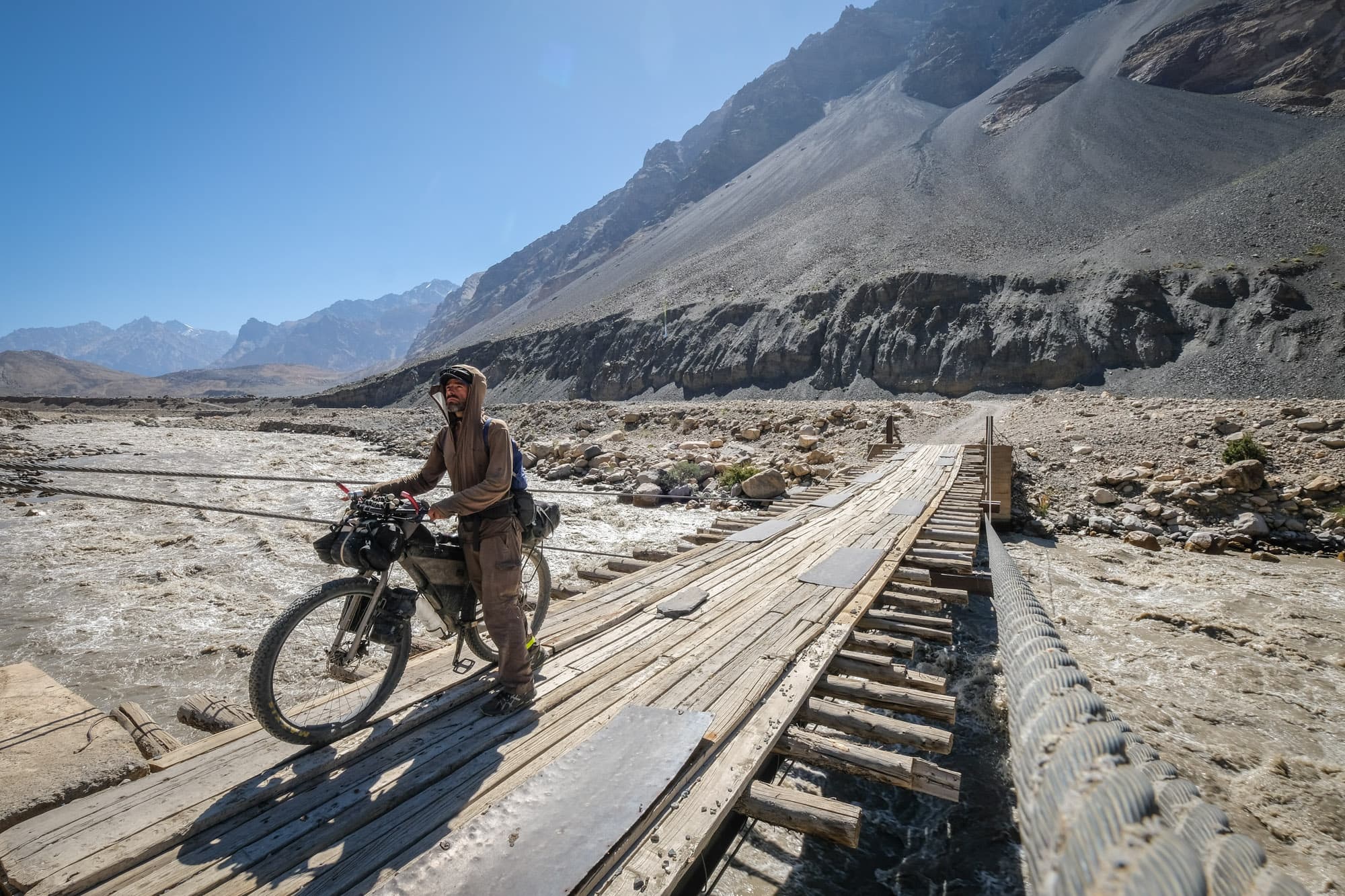 Matthew crosses a wooden road way.