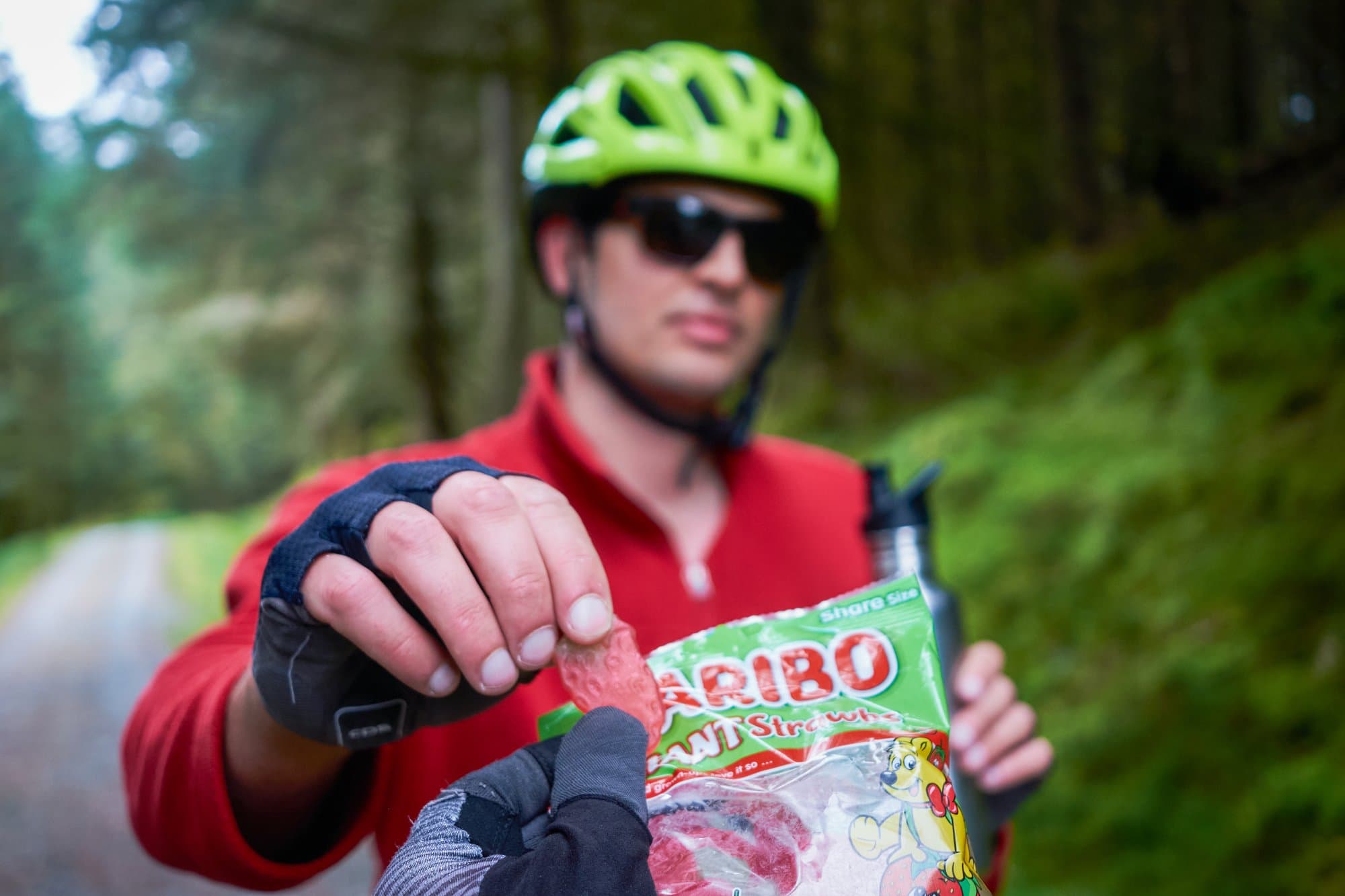 Matteo offers Haribo on a forest road.