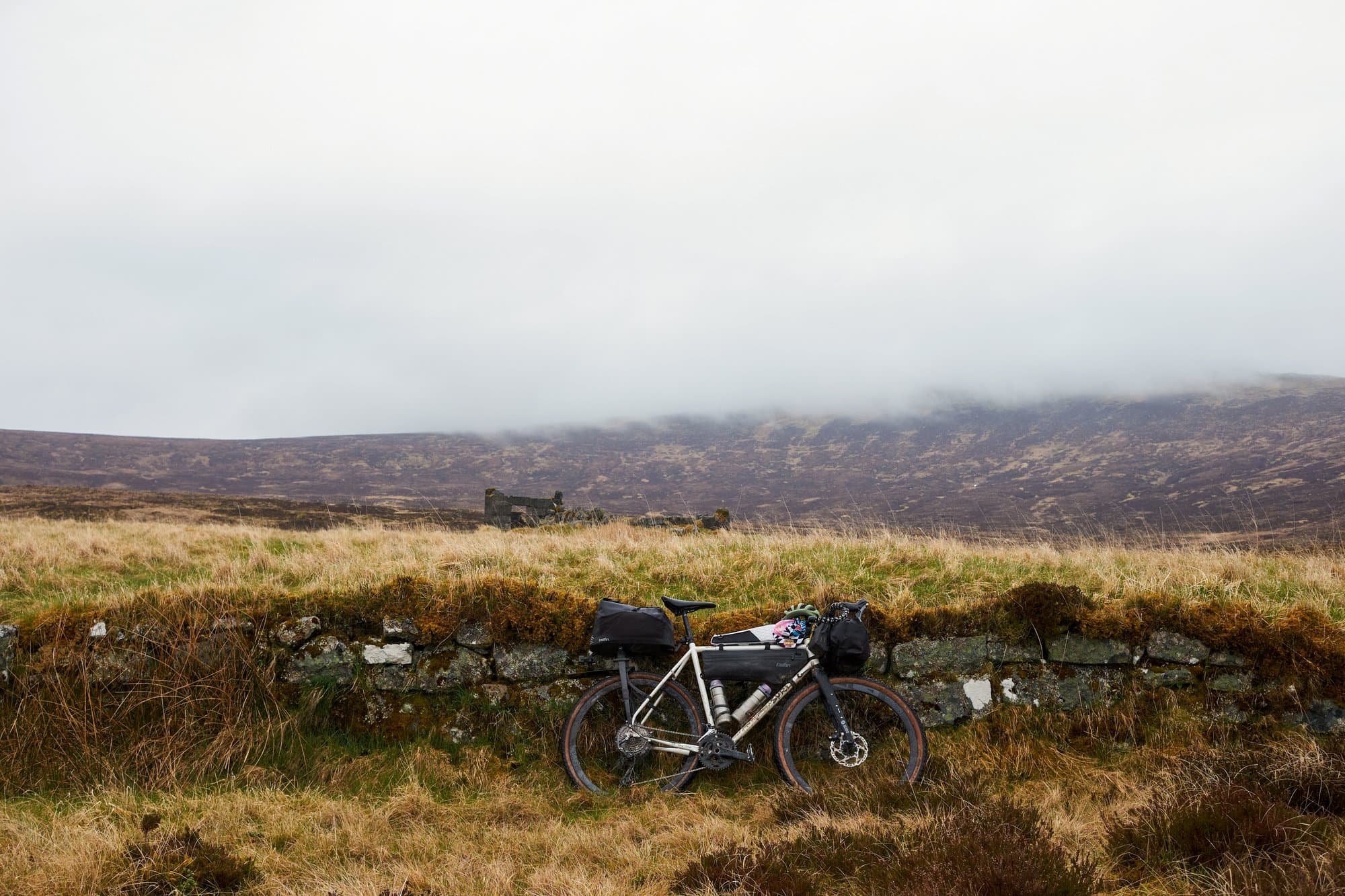 The Surly leaning against a dry-stone wall with fog rolling off the hills.