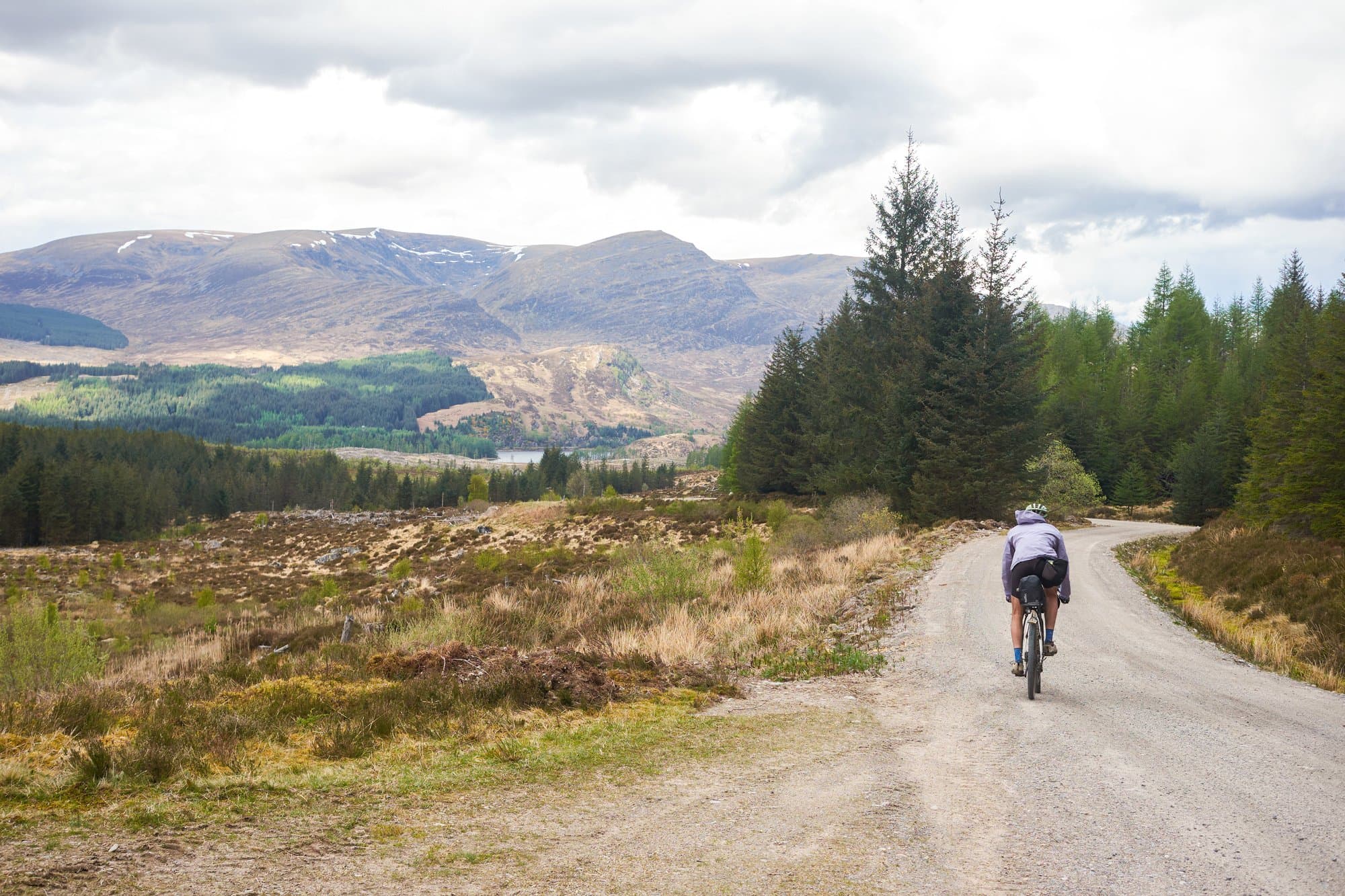 Davide descending a gravel road toward a sea-loch.