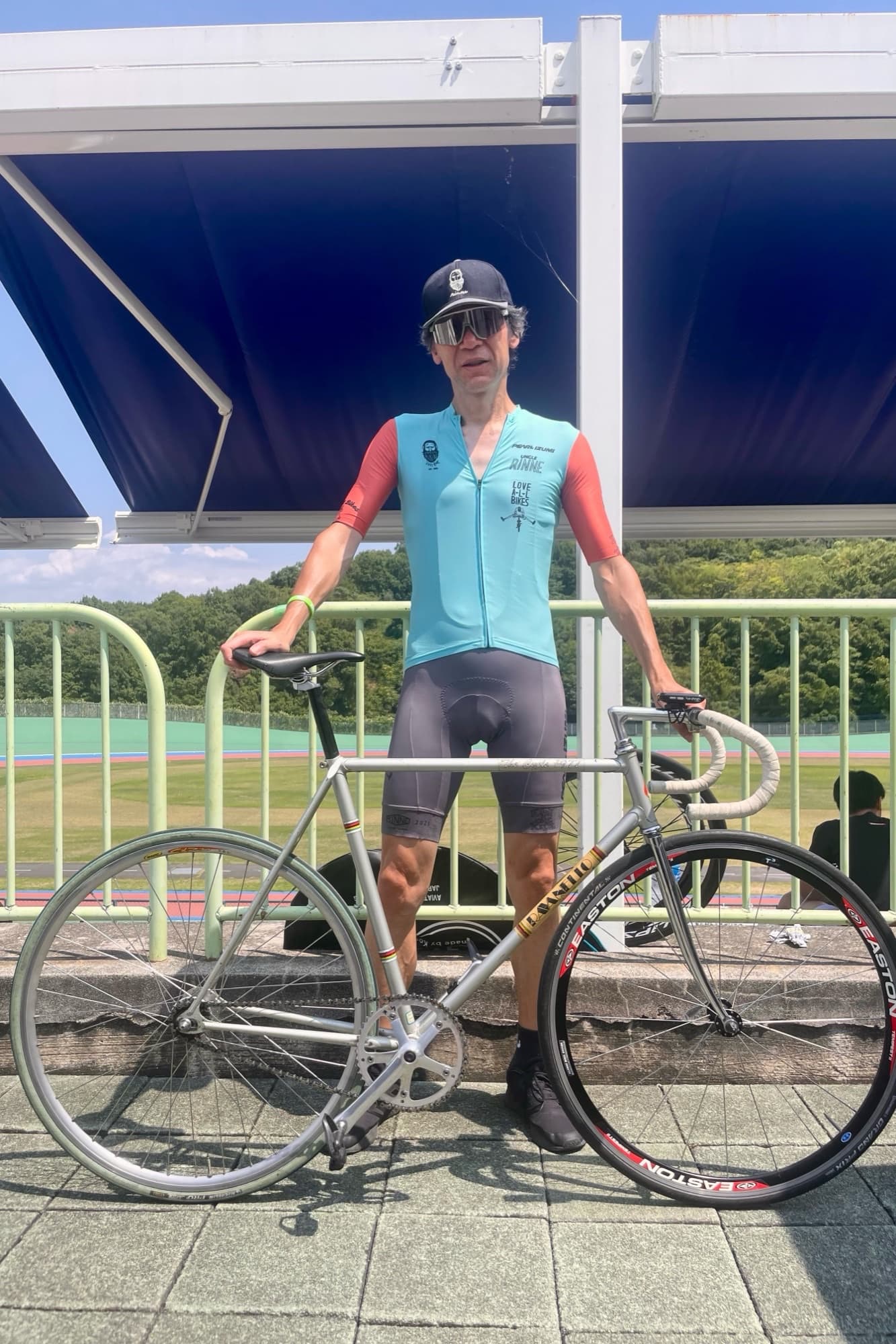 Tetsuro Ohno posing with a silver track bike at a velodrome