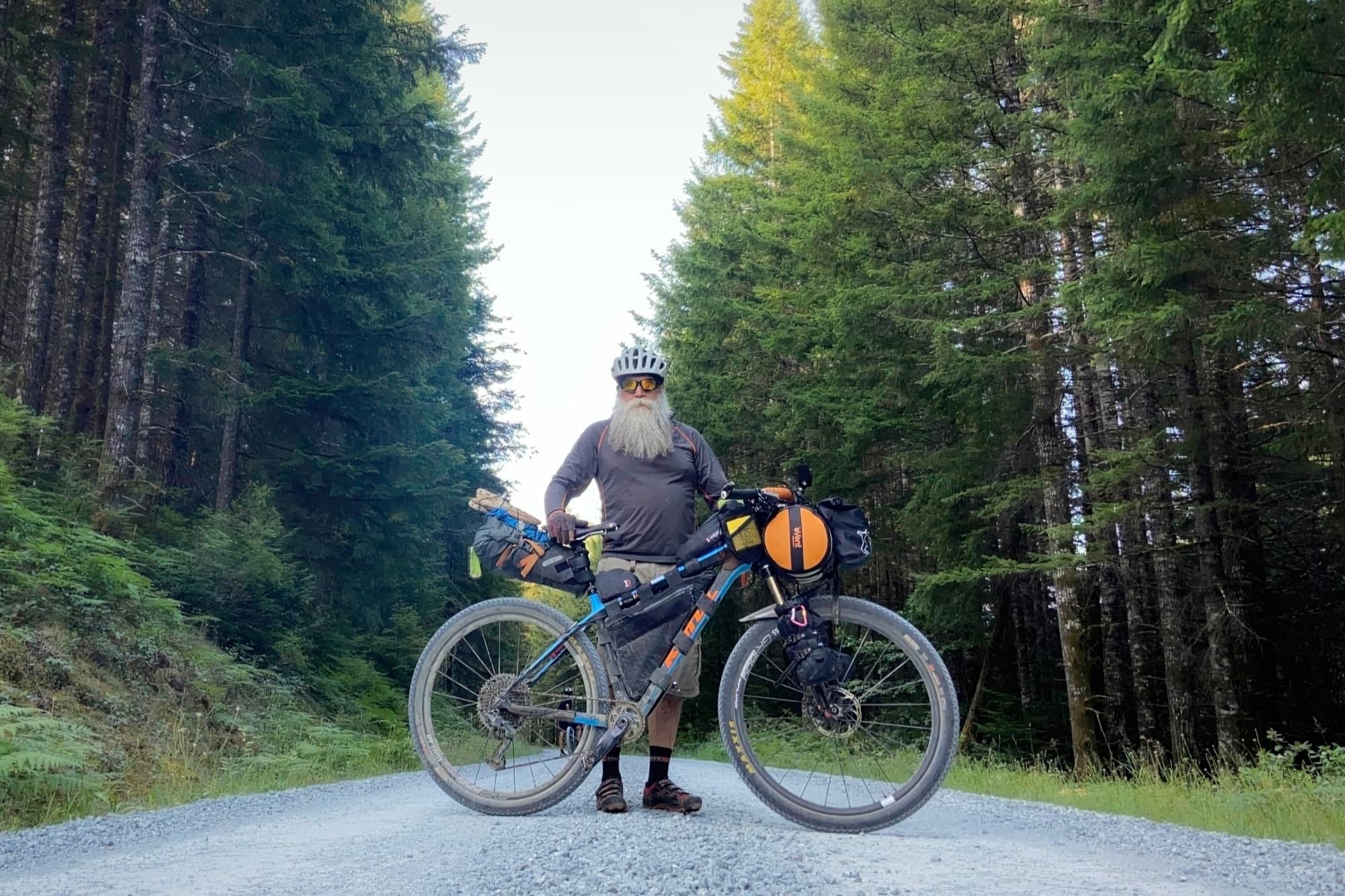 Salty Beard and his loaded rig on a gravel road between the timber
