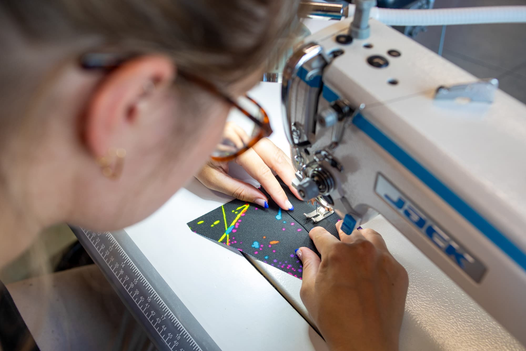 A worker sews bags together.