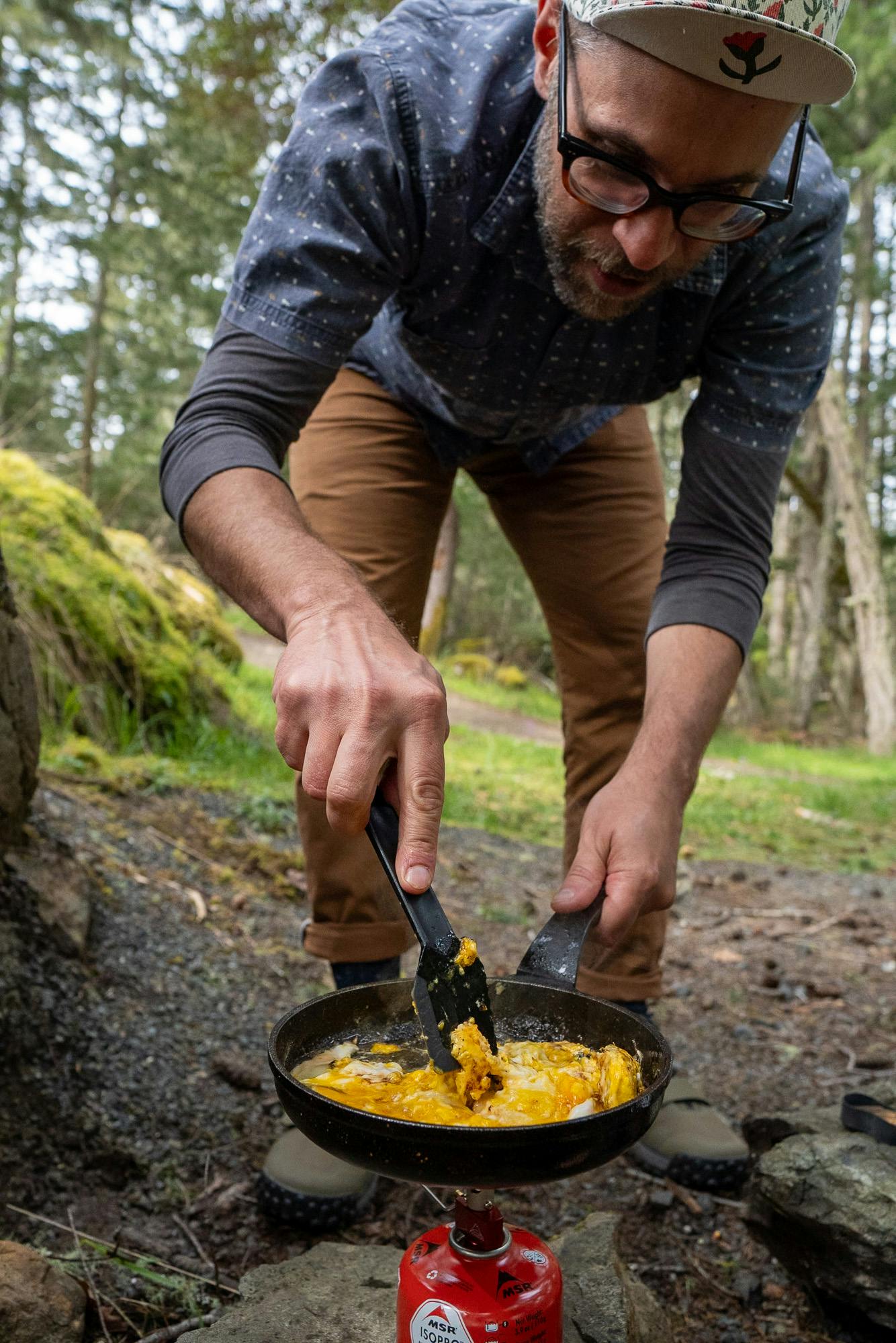 Barry cooks eggs in the forest.