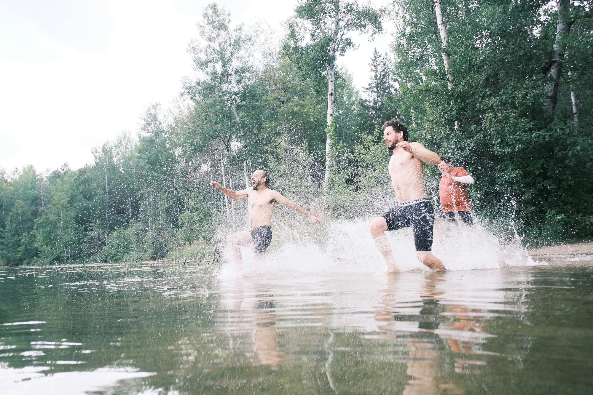Friends jumping in a lake.