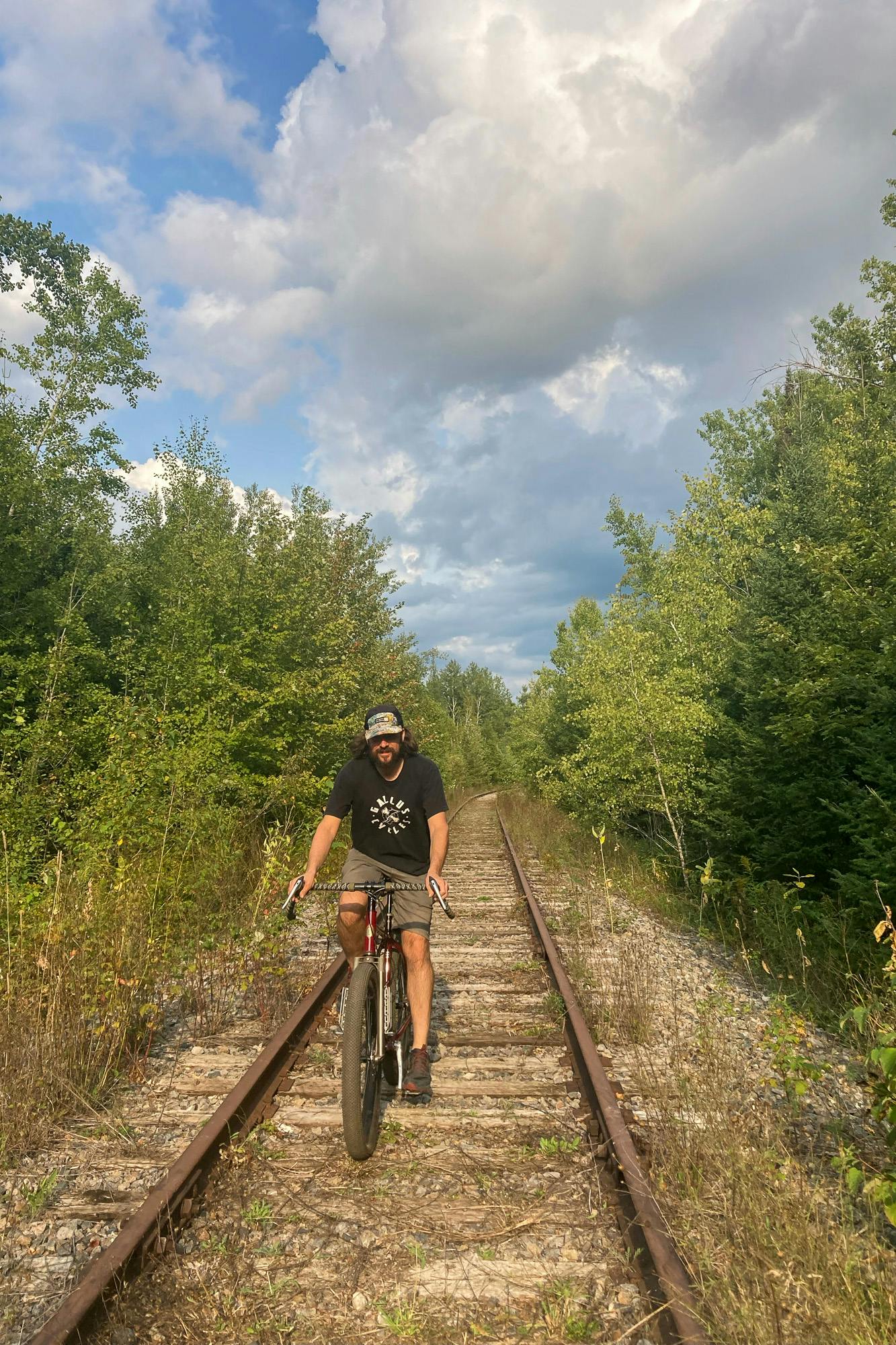 Frank riding a bike along a train track.