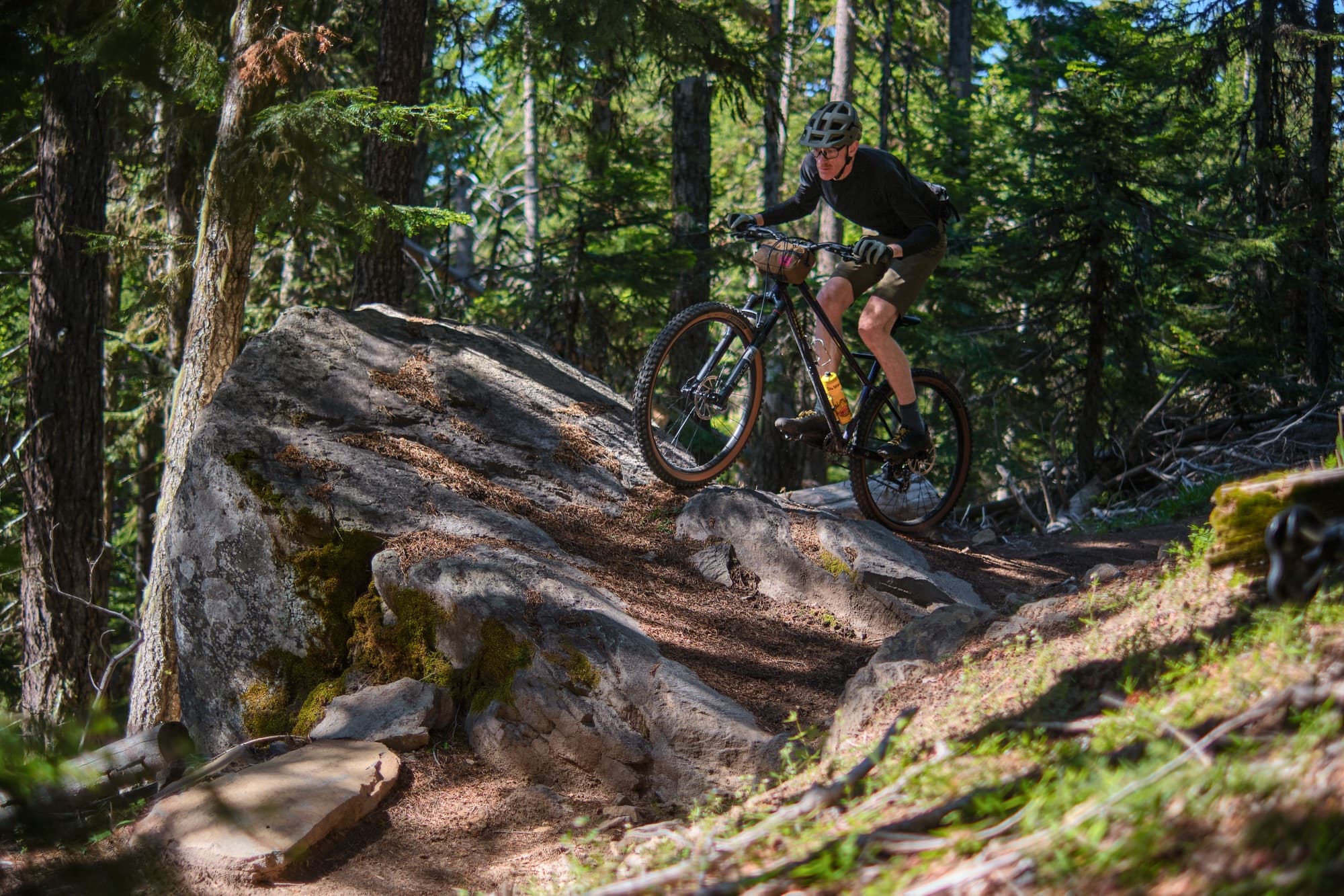 Popping off a boulder in dappled light