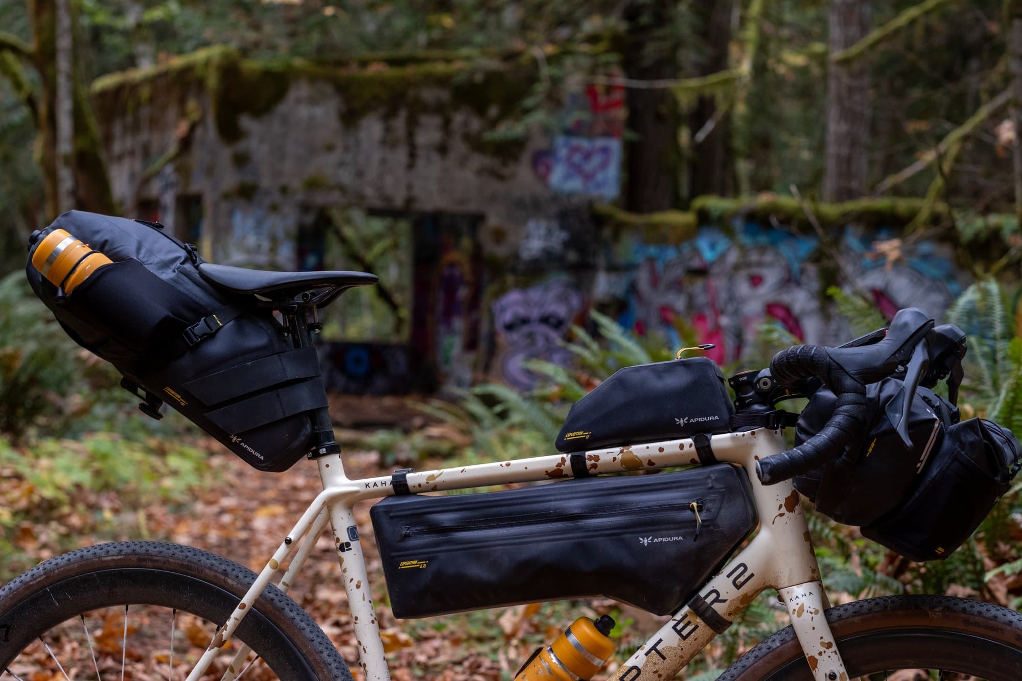 Apidura Expedition kit on the Kaha in graffiti-covered concrete ruins in the forest.