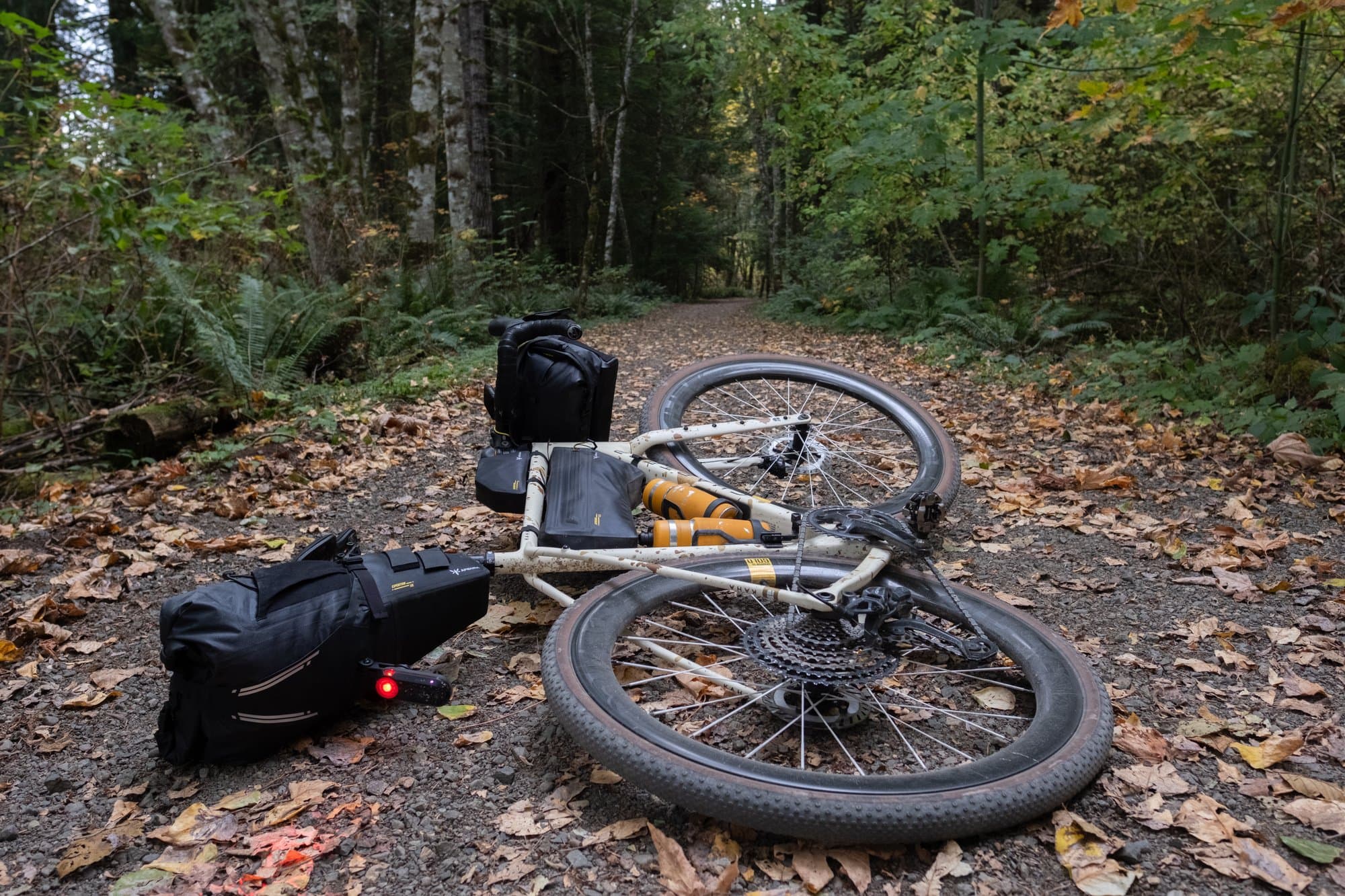 The loaded Kaha laid down on a trail covered in fall leaves.