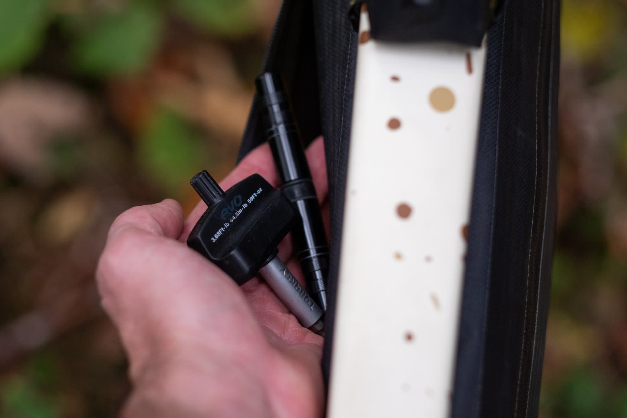 Pulling a multitool and tire plug tool from the Frame Pack's slim map pocket.