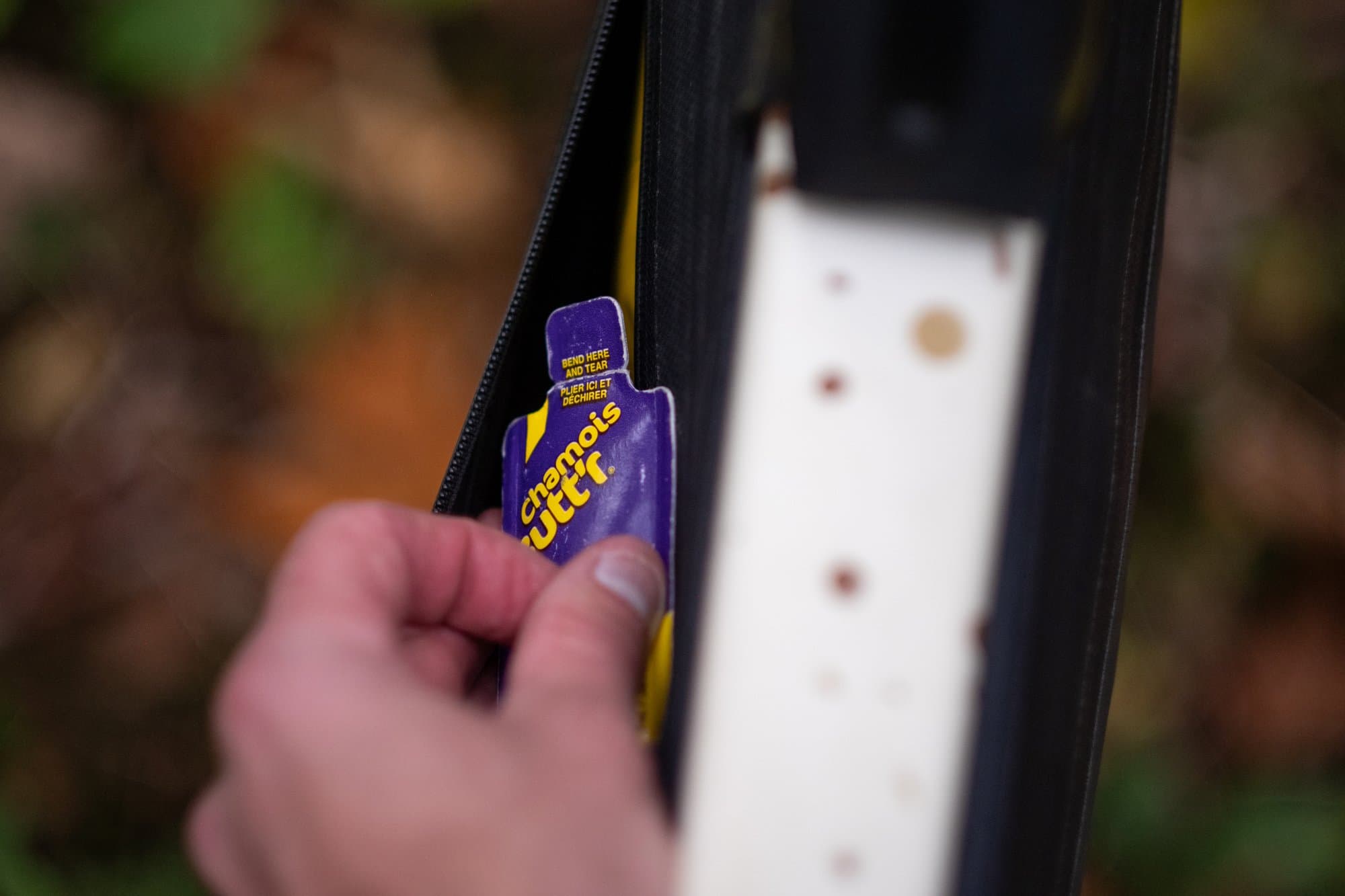 Pulling a single-use Chamois Butt'r packet from the Frame Pack's map pocket.