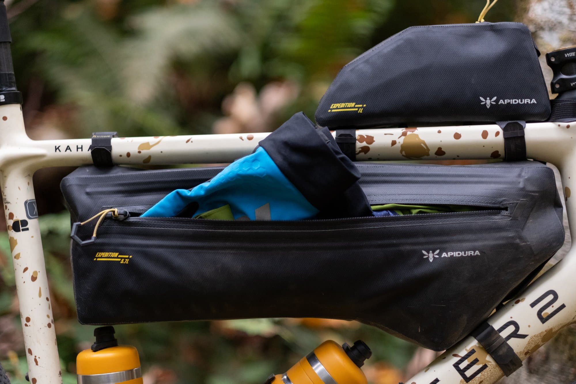The Expedition Frame Pack unzipped with a jacket inside, Top Tube Pack above.