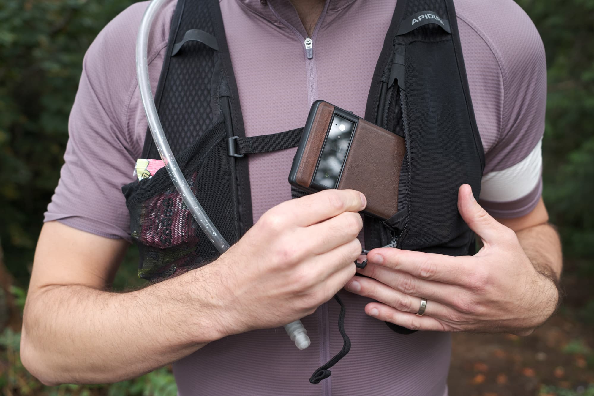 Jeff puts his phone in the Apidura Racing Hydration Vest font pocket.