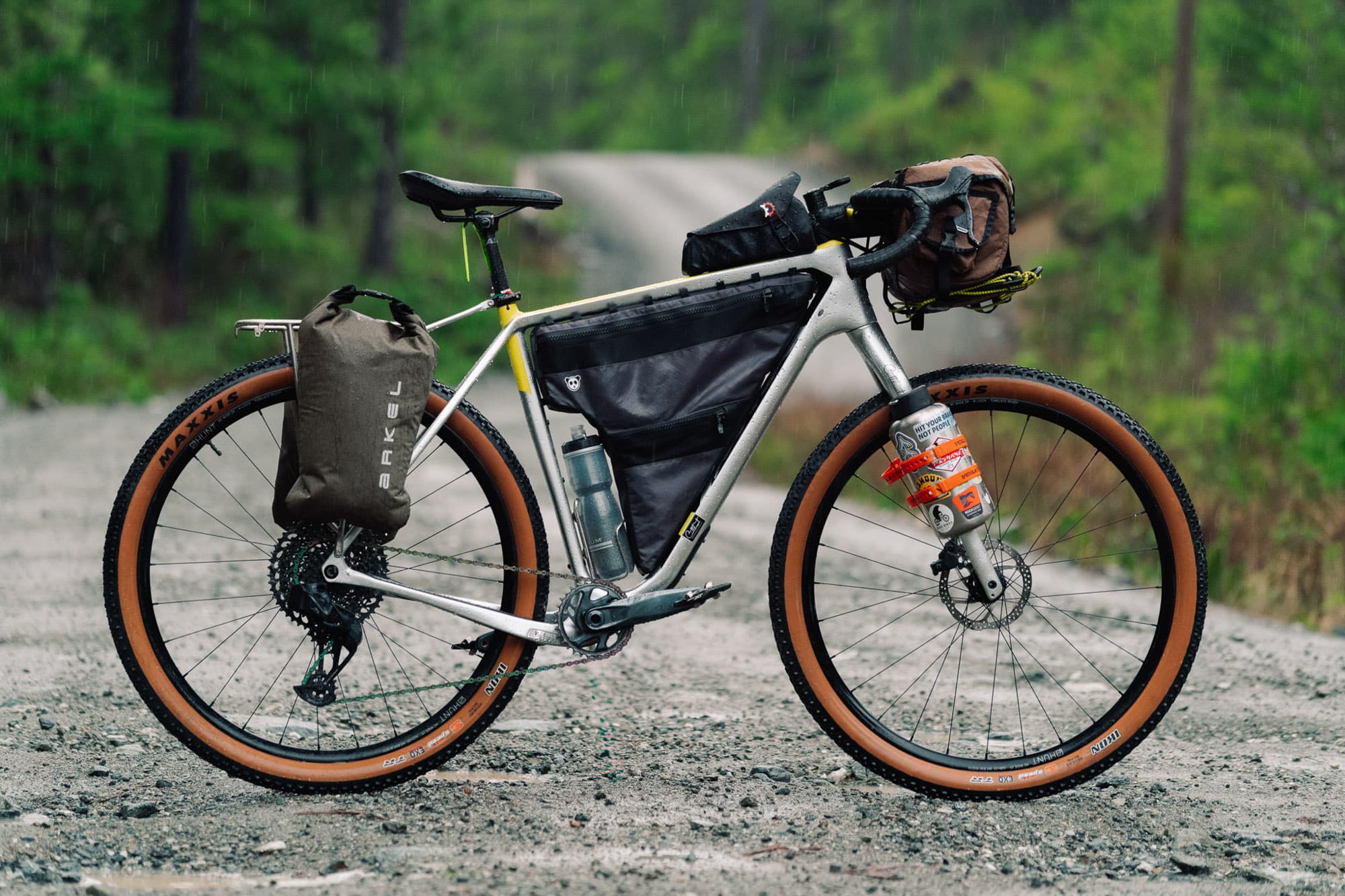 Arkel Forkpackers loaded on a fully rigged bikepacking bike, side profile on a gravel road.