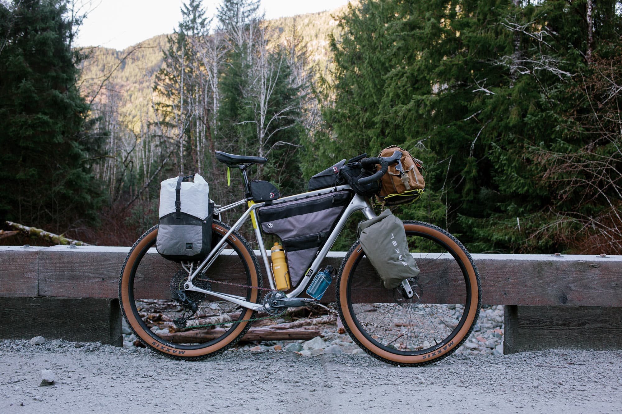 Loaded bike leaning against a concrete barrier.