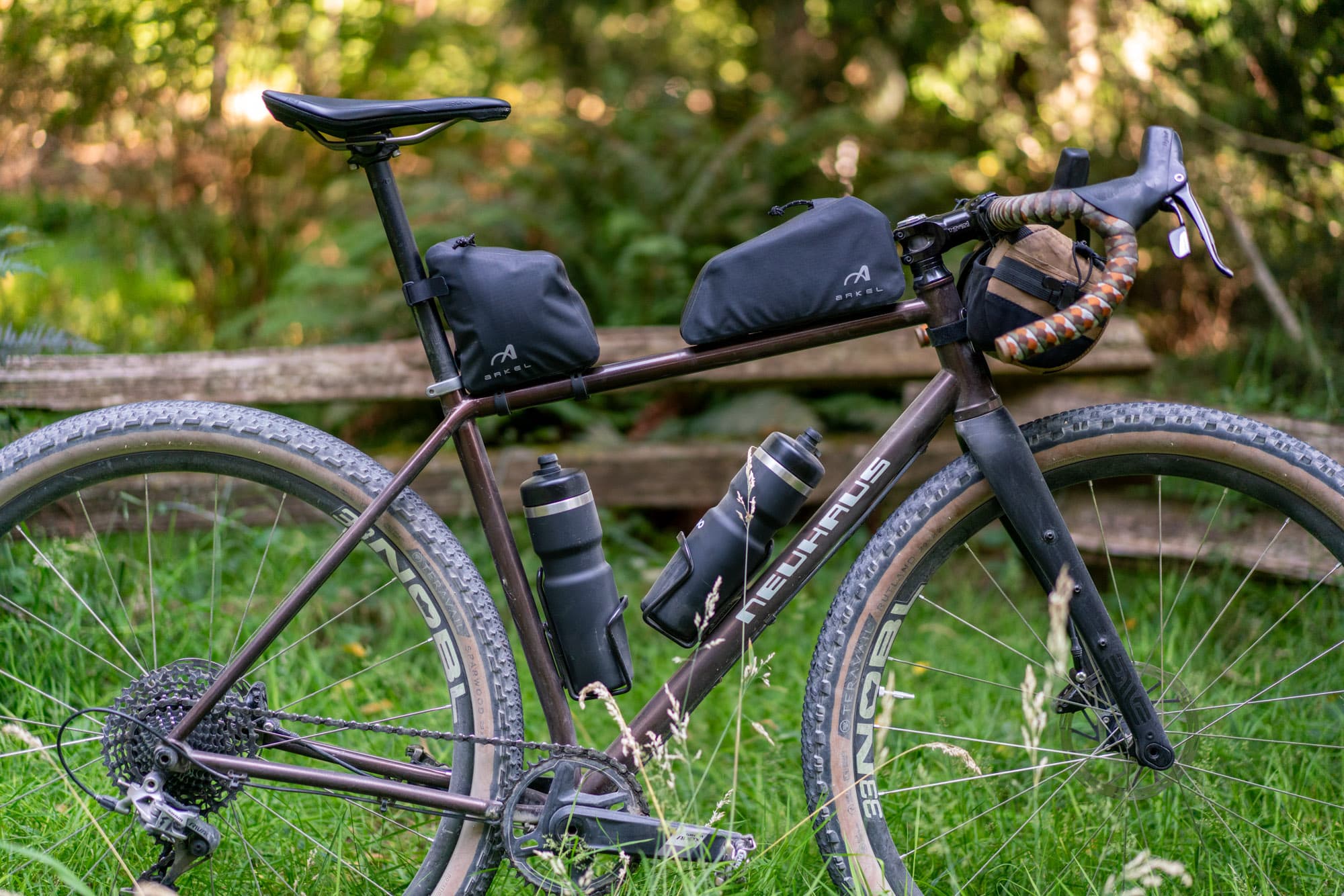 Both Arkel top tube bags mounted on the BigLeaf, parked against a wooden railing.