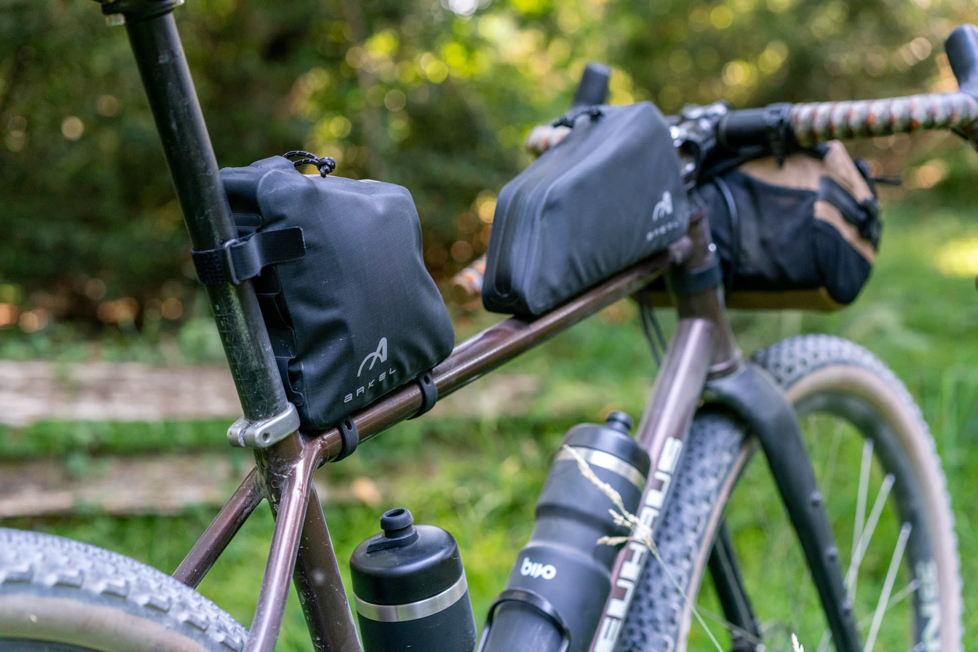 Front and rear Arkel bags mounted alongside two black Bivo bottles.