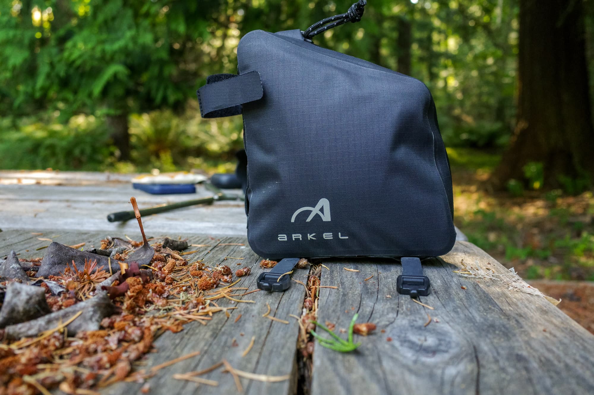 The Arkel rear bag resting on a picnic table, straps hanging loose.