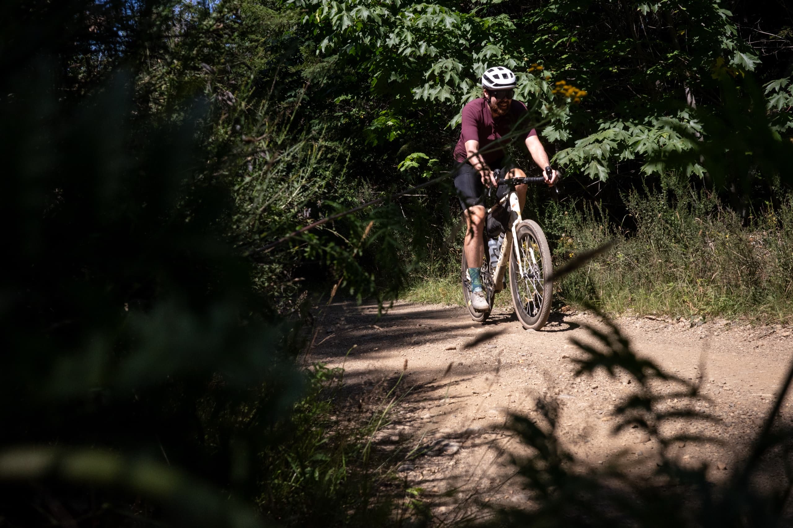 Jeff riding into a shaded section of gravel trail on Vancouver Island.
