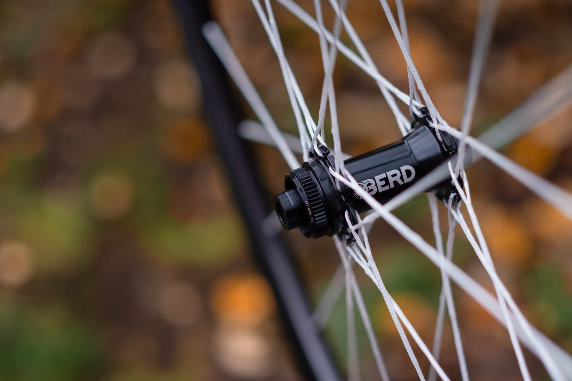 Macro detail of a Berd hub laced with white dyneema spokes.