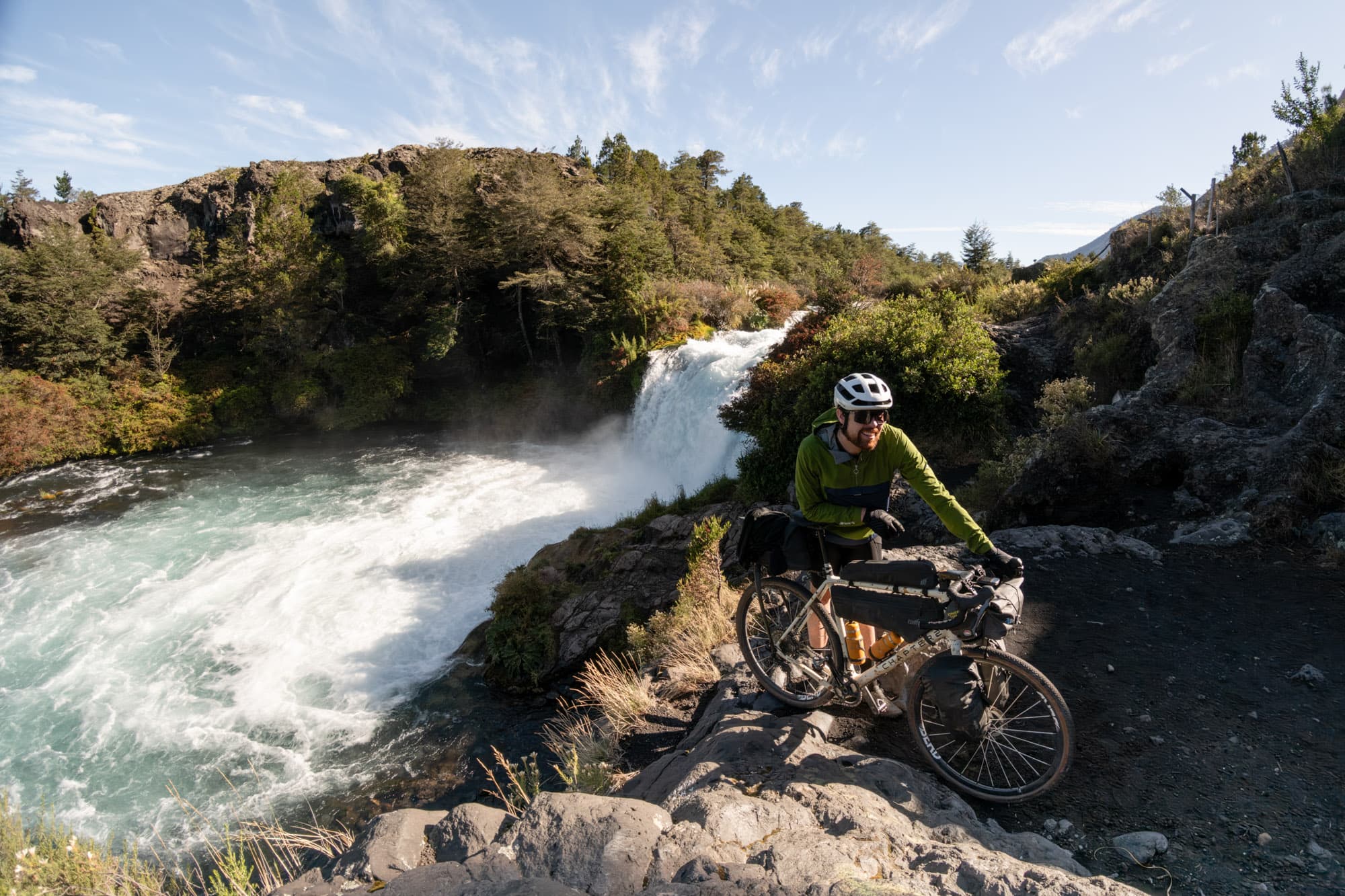 Stopping the loaded bike beside a powerful Patagonian waterfall.