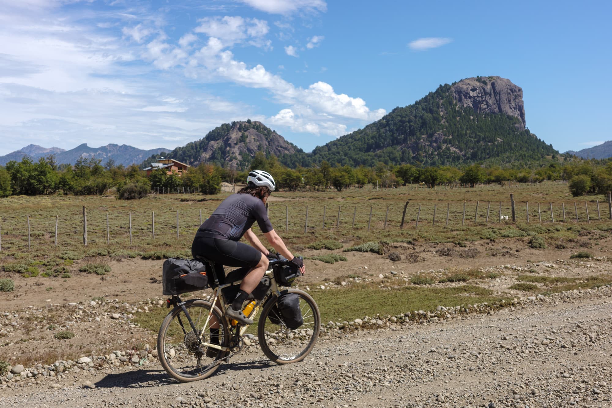 Riding past a rocky volcanic pinnacle on Patagonian plains.