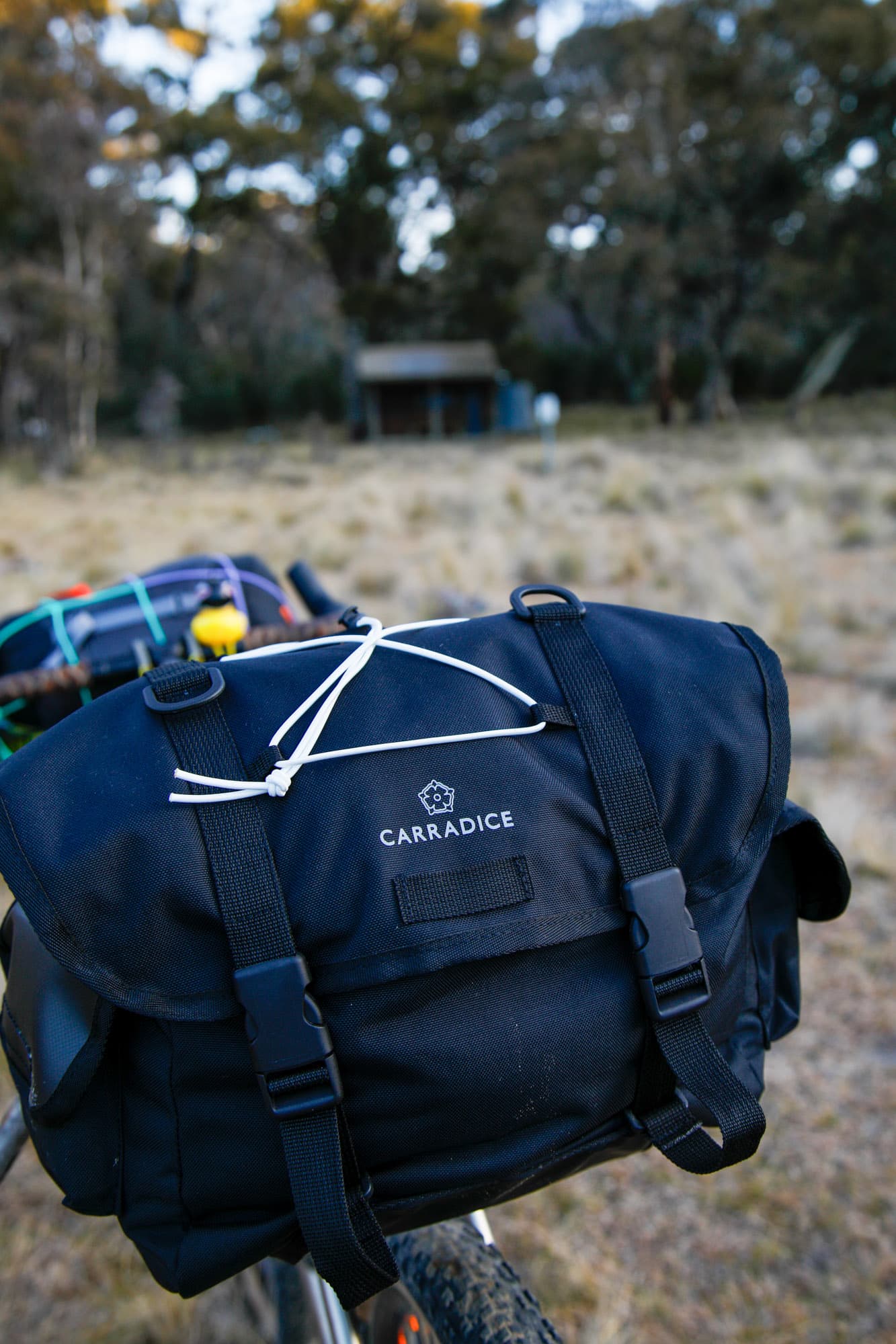 The Carradice Odyssey's classic longflap and white bungee at a dusk campsite.