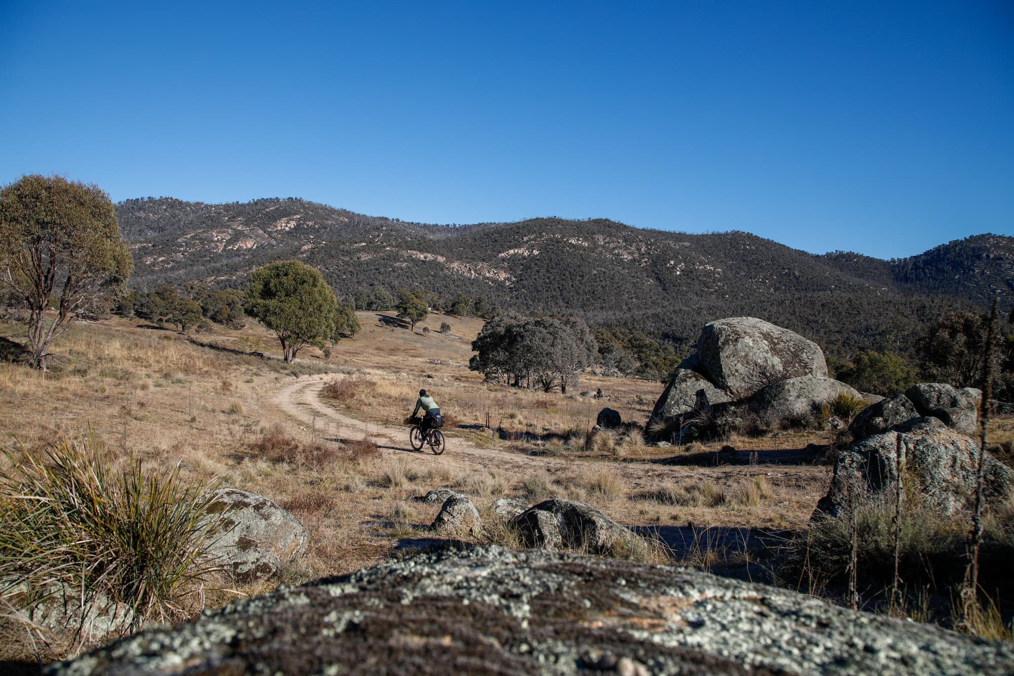 Riding doubletrack through boulder-strewn grassland in the hills.