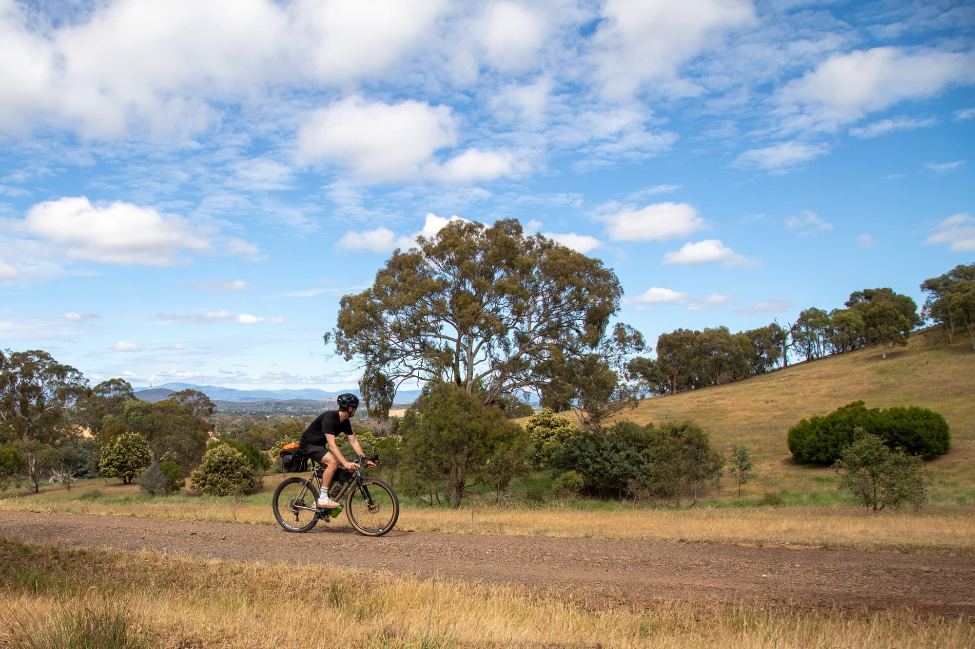 Riding a gravel road through green rolling hills.