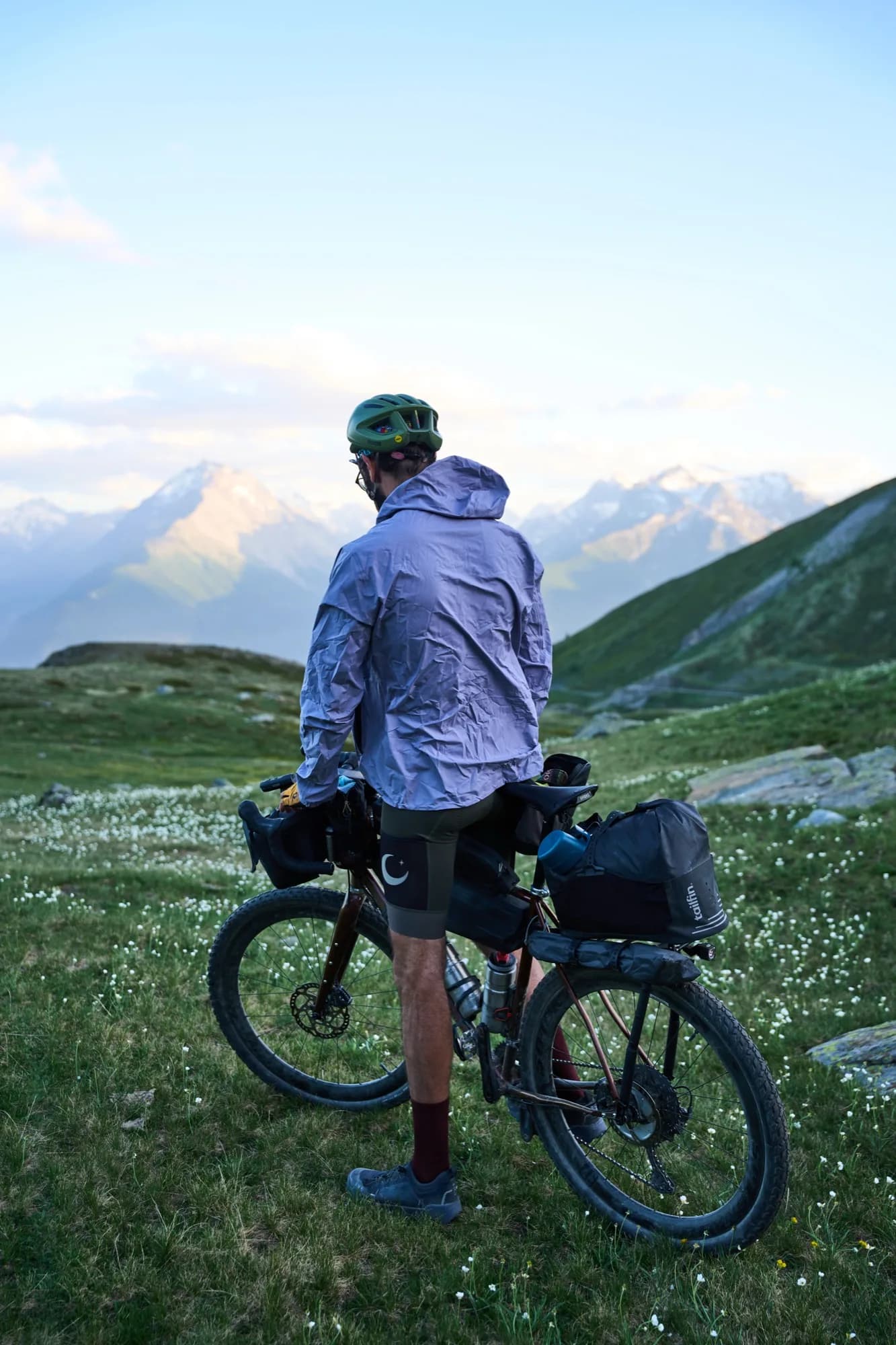 Davide and his fully loaded bike looking out over the mountains in evening light