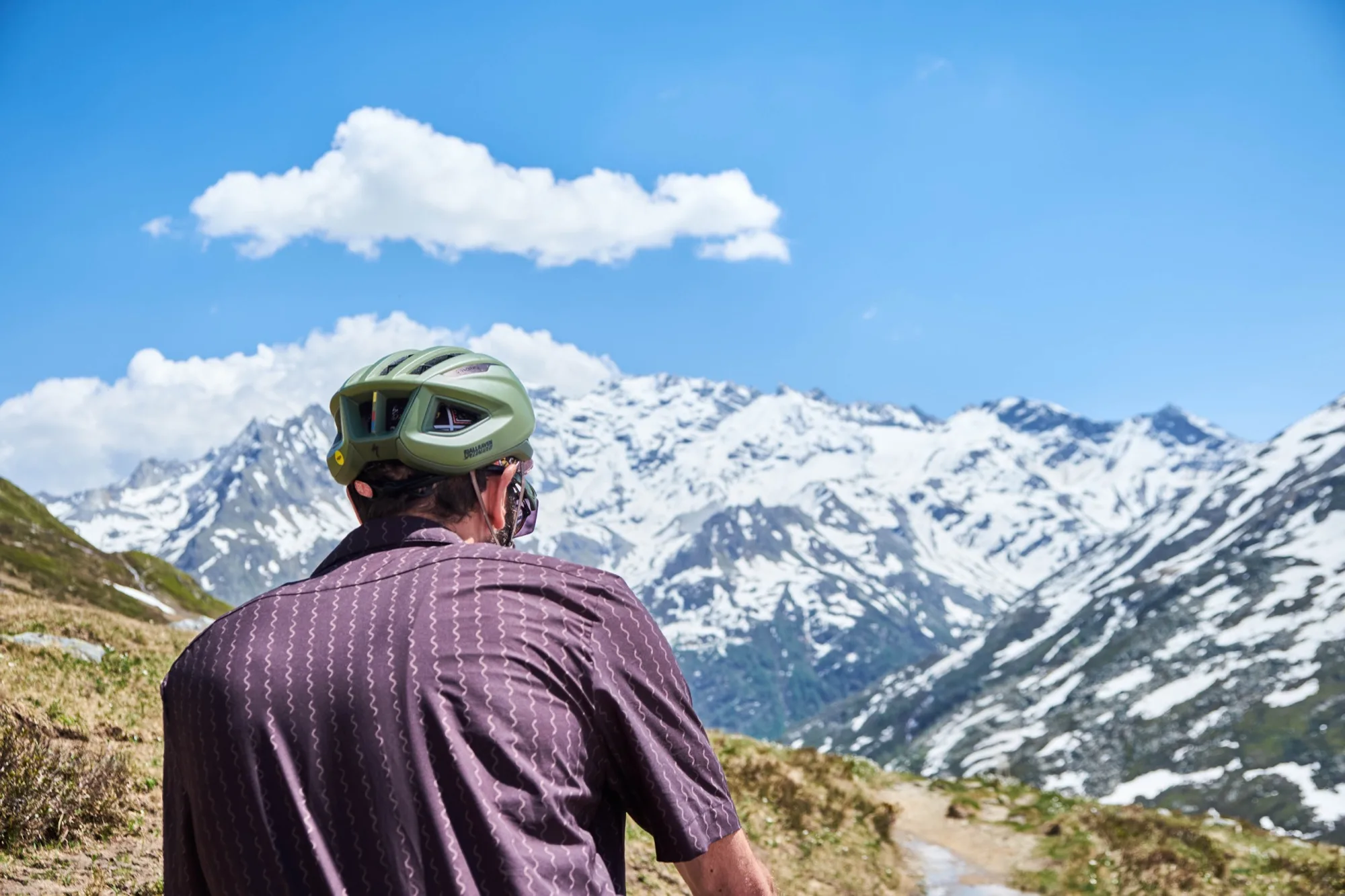 Rear view of Davide in the Cascada shirt looking out at snow-covered mountains
