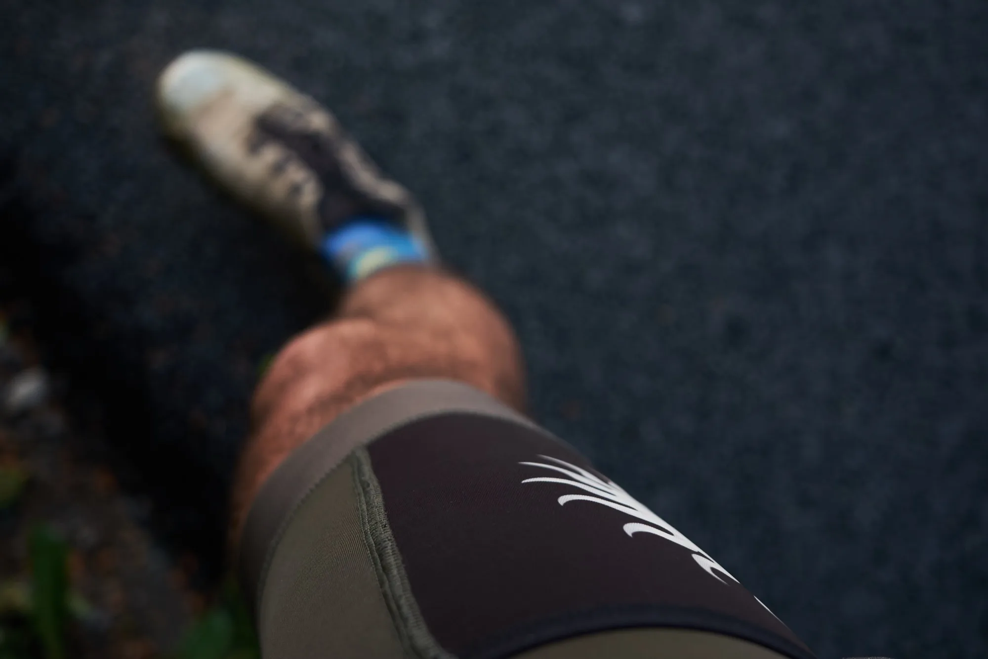 Point-of-view look down at the bib shorts cargo thigh pocket while pedalling