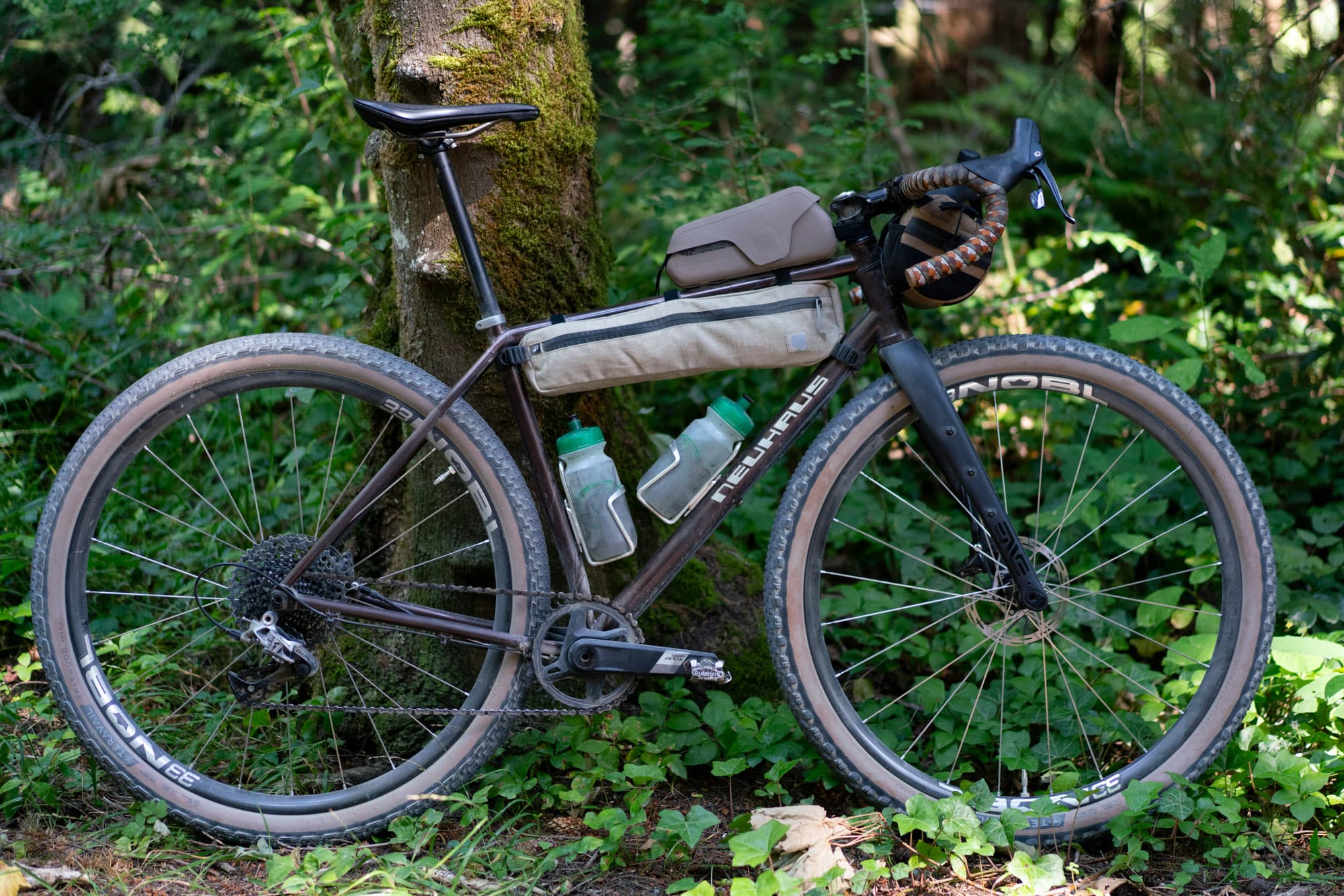 The Neuhaus BigLeaf against a mossy trunk, both Decathlon bags mounted.