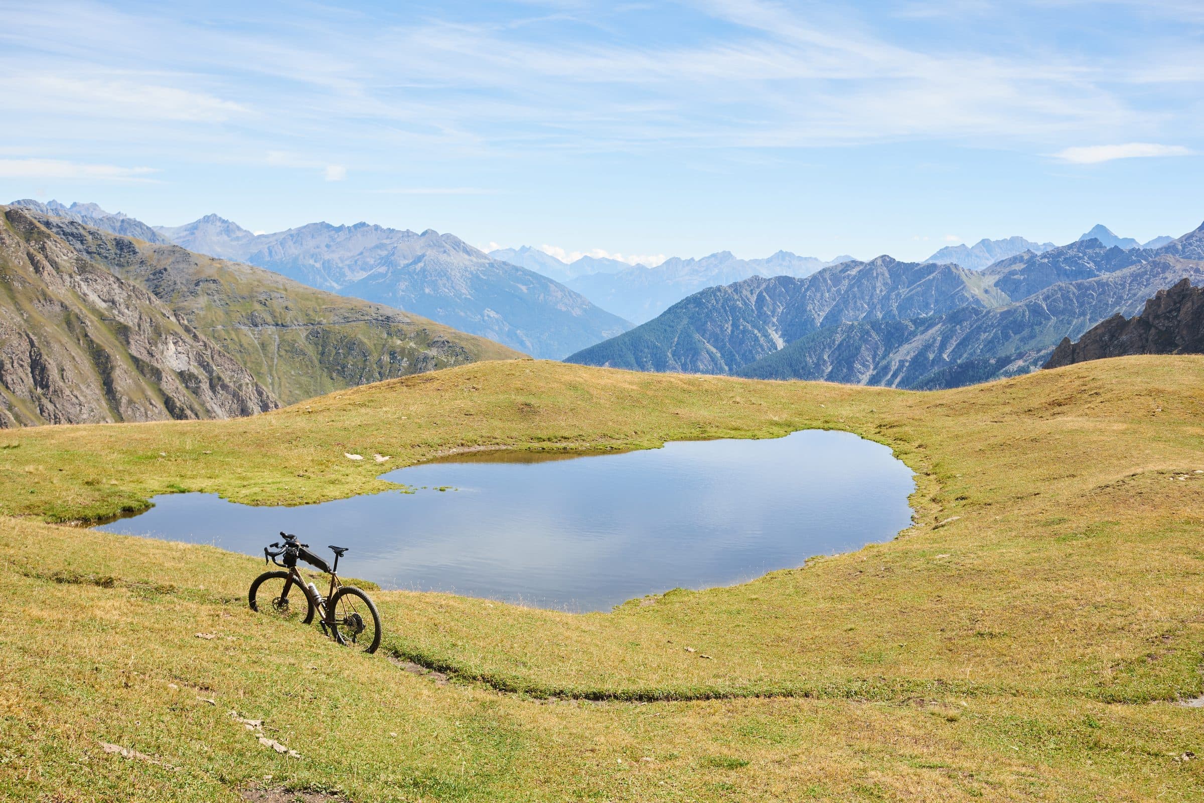 Davide's loaded gravel bike beside an Alpine lake.