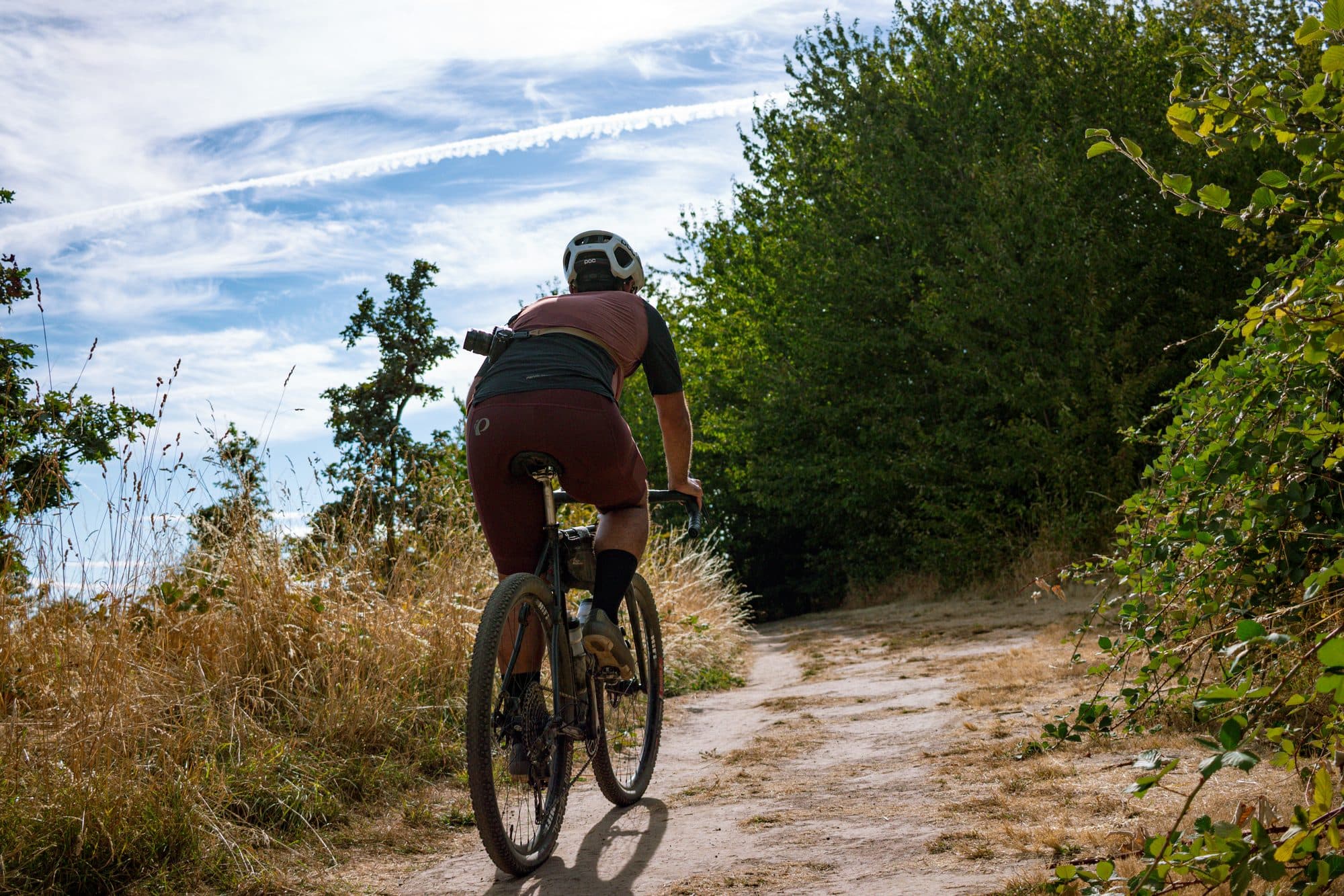 Riding away down a sandy trail in the Pearl Izumi Expedition kit.