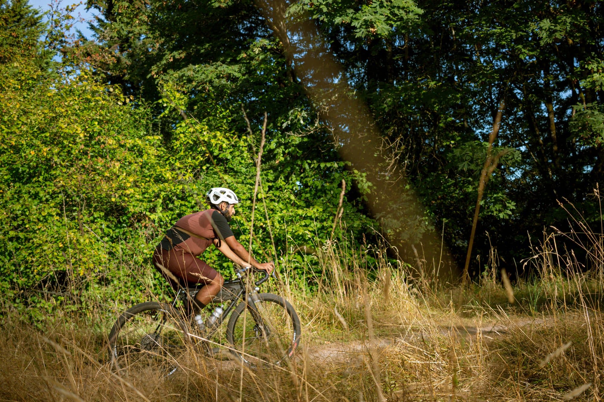 Brushing past overgrown trail edges in the sun.
