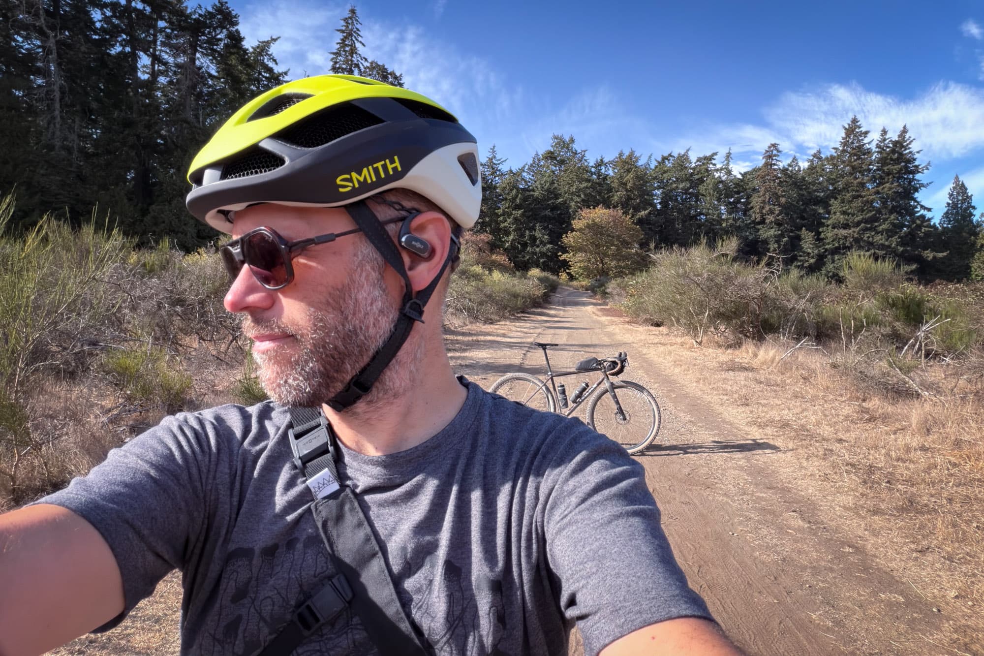 Barry in the Smith Trace on a sunny gravel road, his bike parked behind him.