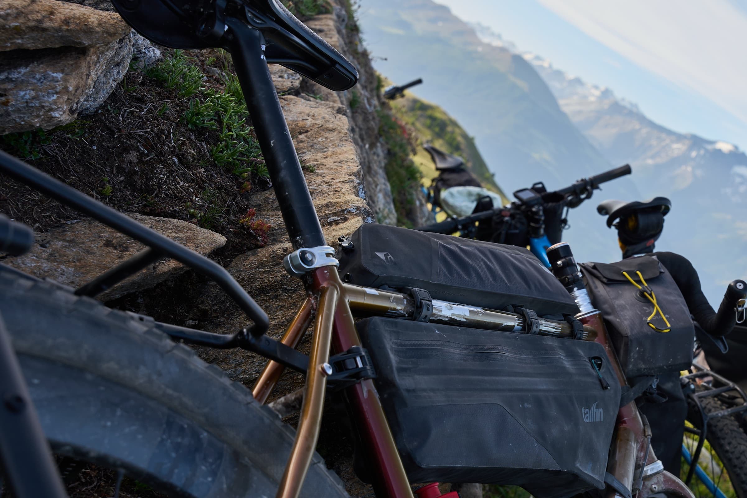 The Journey Pannier Rack and frame bag mounted low on the bike, shot from a cliffside trail overlooking the coast.
